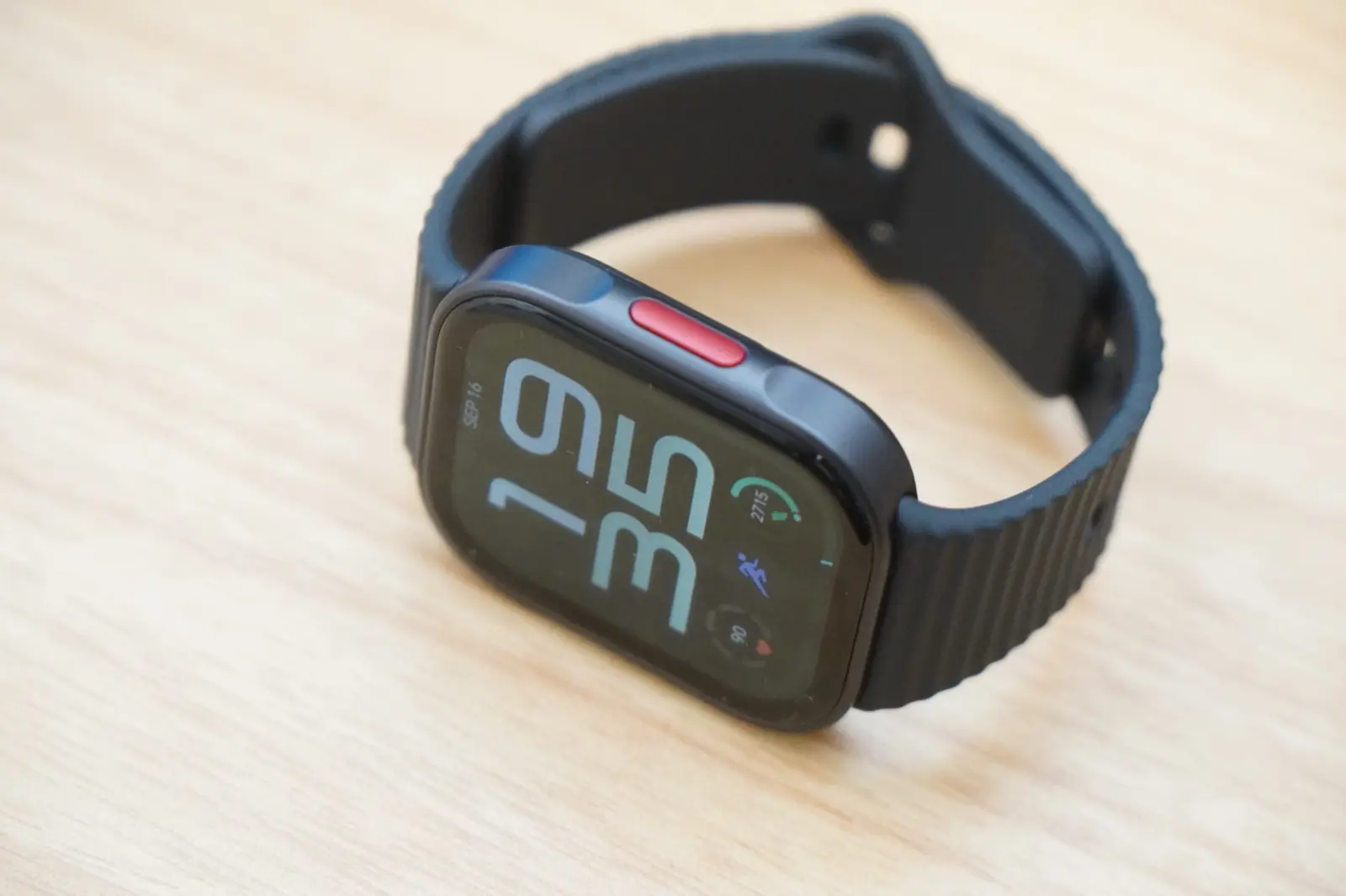 REDMI Watch 6 Liteを斜め横から見たところ。右側面に赤いサイドボタンがあり、フレームは金属調の仕上げ
