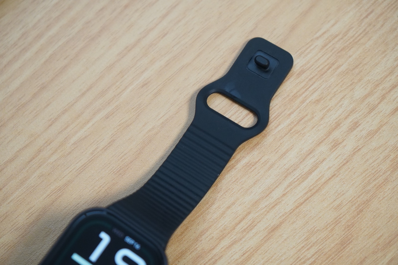 REDMI Watch 6 Liteの黒いTPUストラップ。波形のテクスチャーと、穴に通して留めるピン式のバックルが写っている