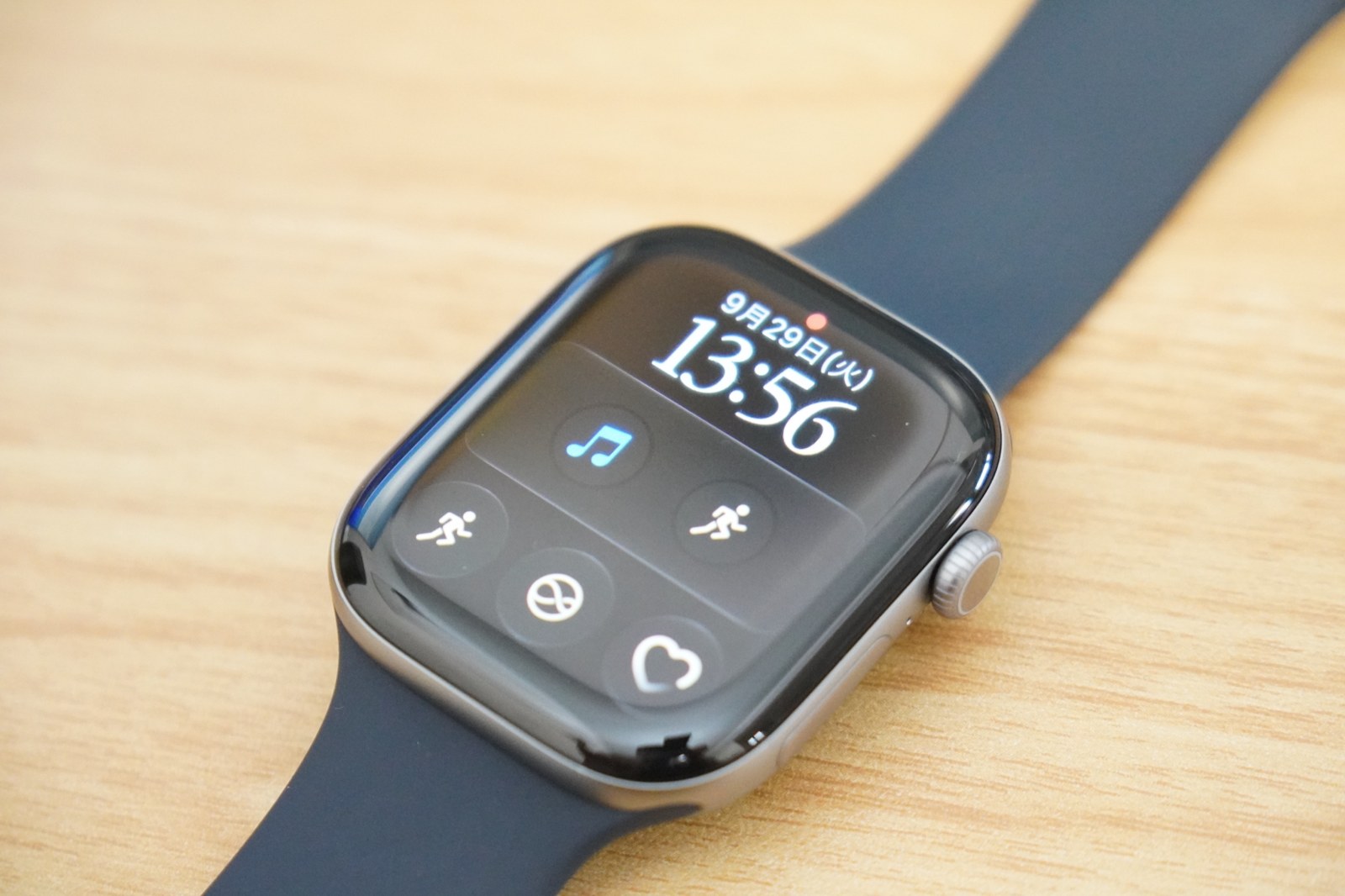 机に置いたApple Watch Series 12。46mmのスペースグレイアルミニウムケースにネイビーブルーのスポーツバンド