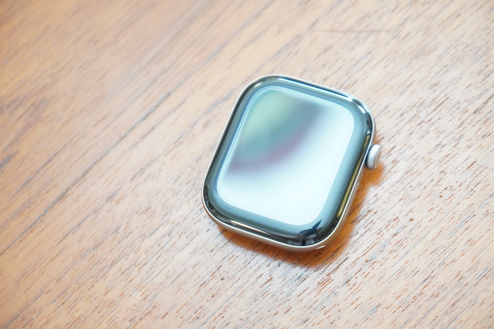 机に置いたApple Watch Series 12の前面。アルミニウムケースのCeramic Shield 2のガラスに光が映り込んでいる