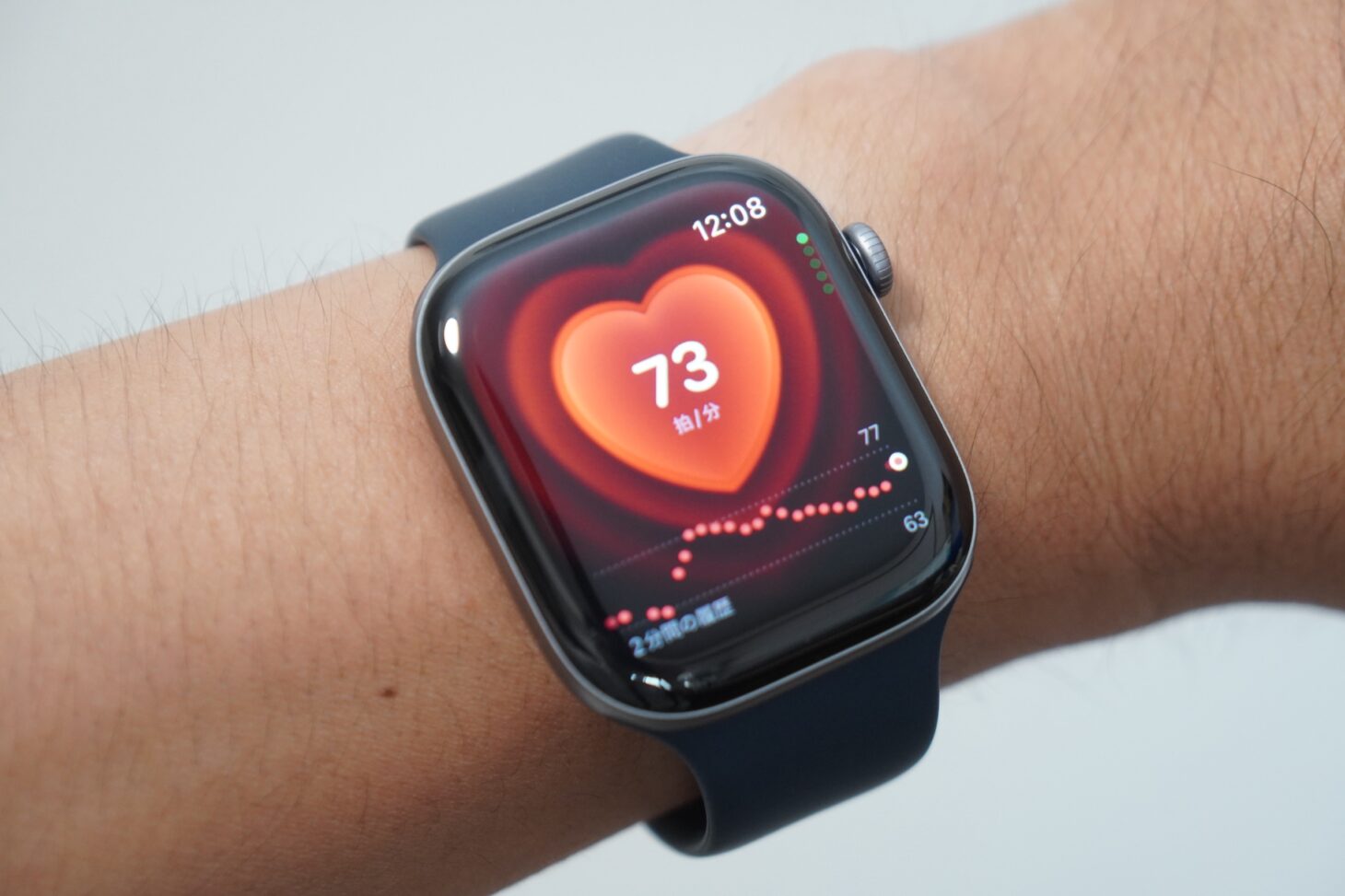 腕に着けたApple Watch Series 12の心拍数アプリ。73拍/分と2分間の履歴