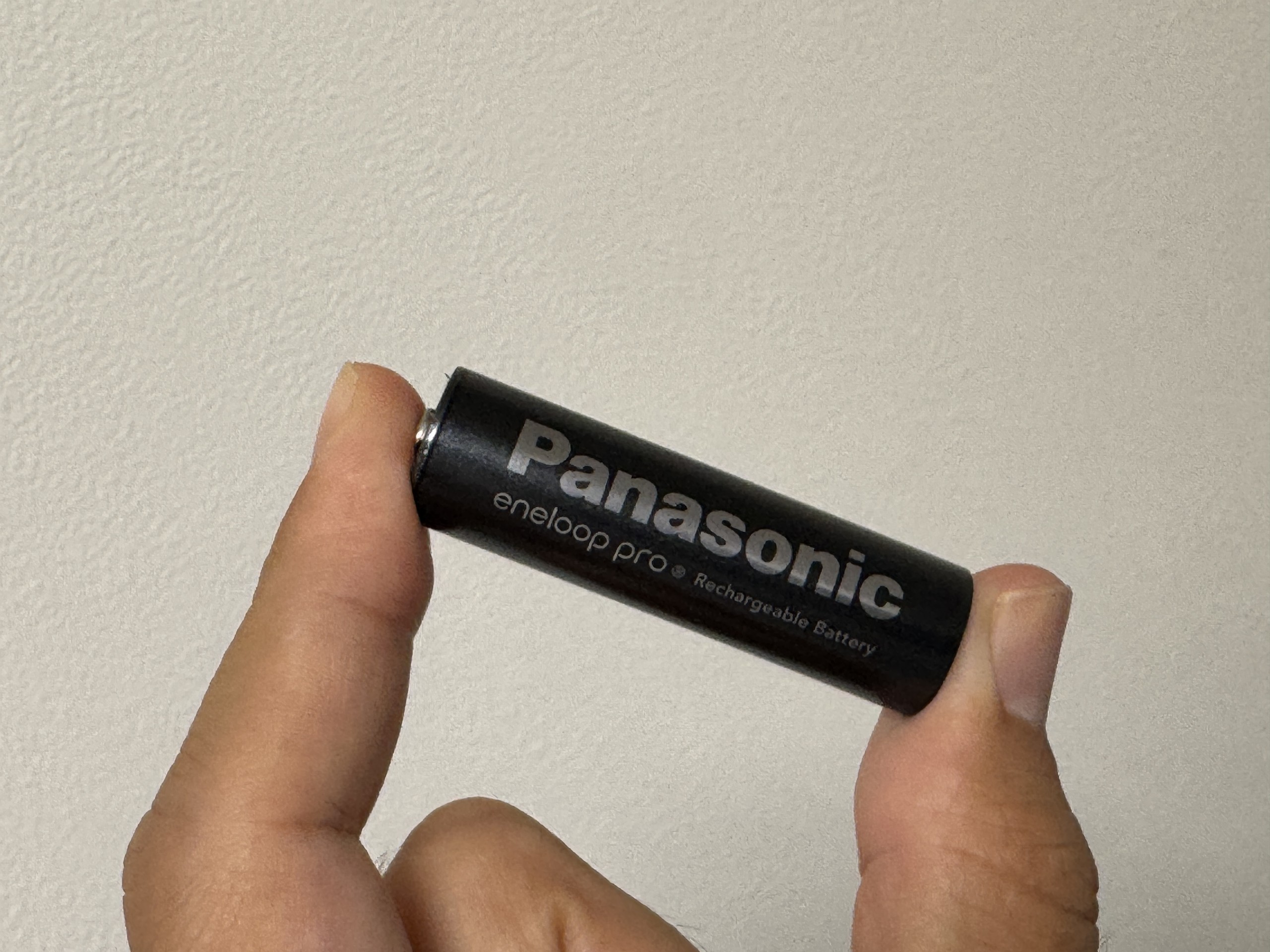 黒いエネループ プロ 単3形を指で横向きに持ったところ。Panasonic、eneloop pro、Rechargeable Batteryの文字が読める
