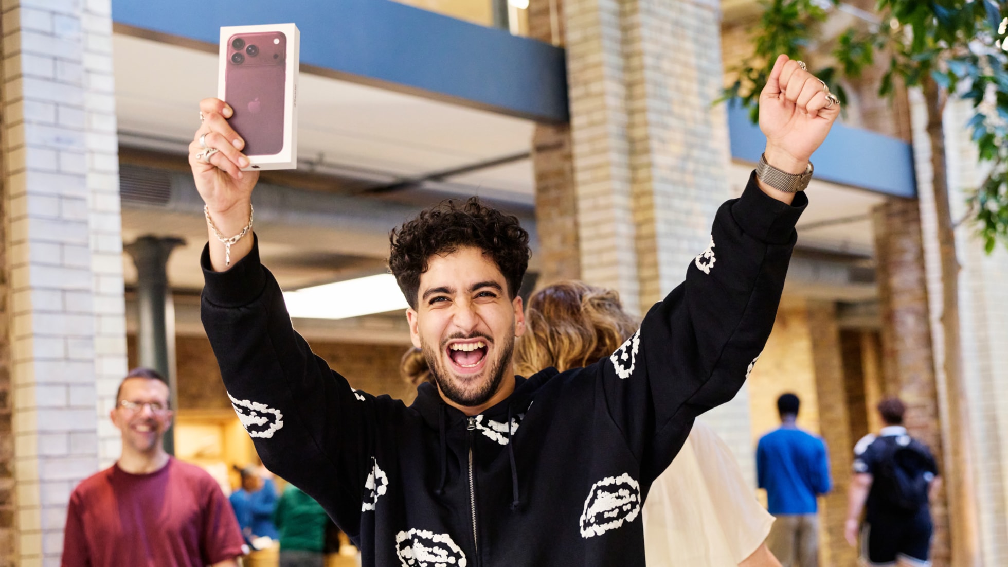 Apple Covent GardenでバーガンディのカラーのiPhone 18 Proを購入して喜んでいる来店客。