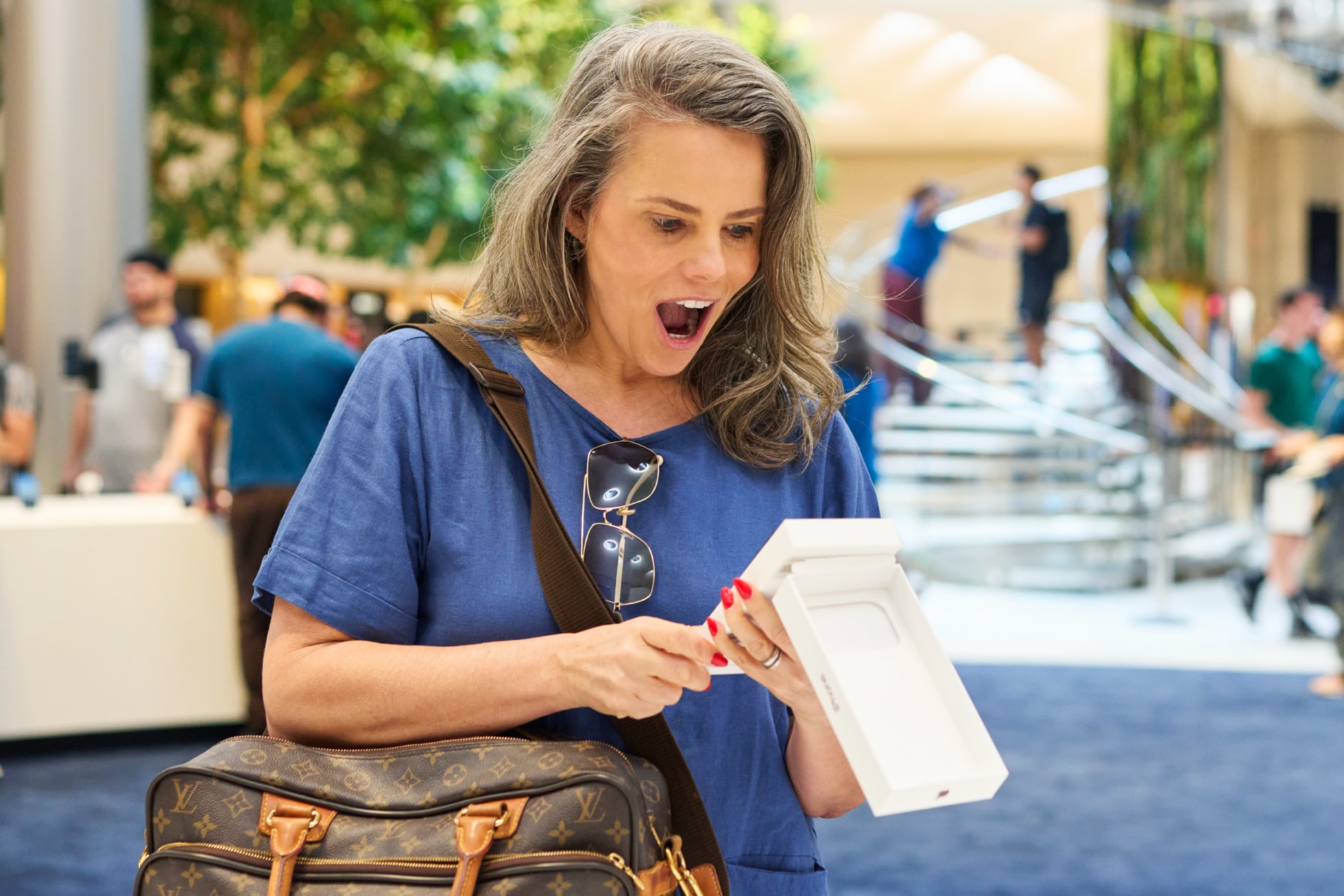 Apple Fifth Avenueで購入した新しいiPhone 18 Proを箱から出している来店客。