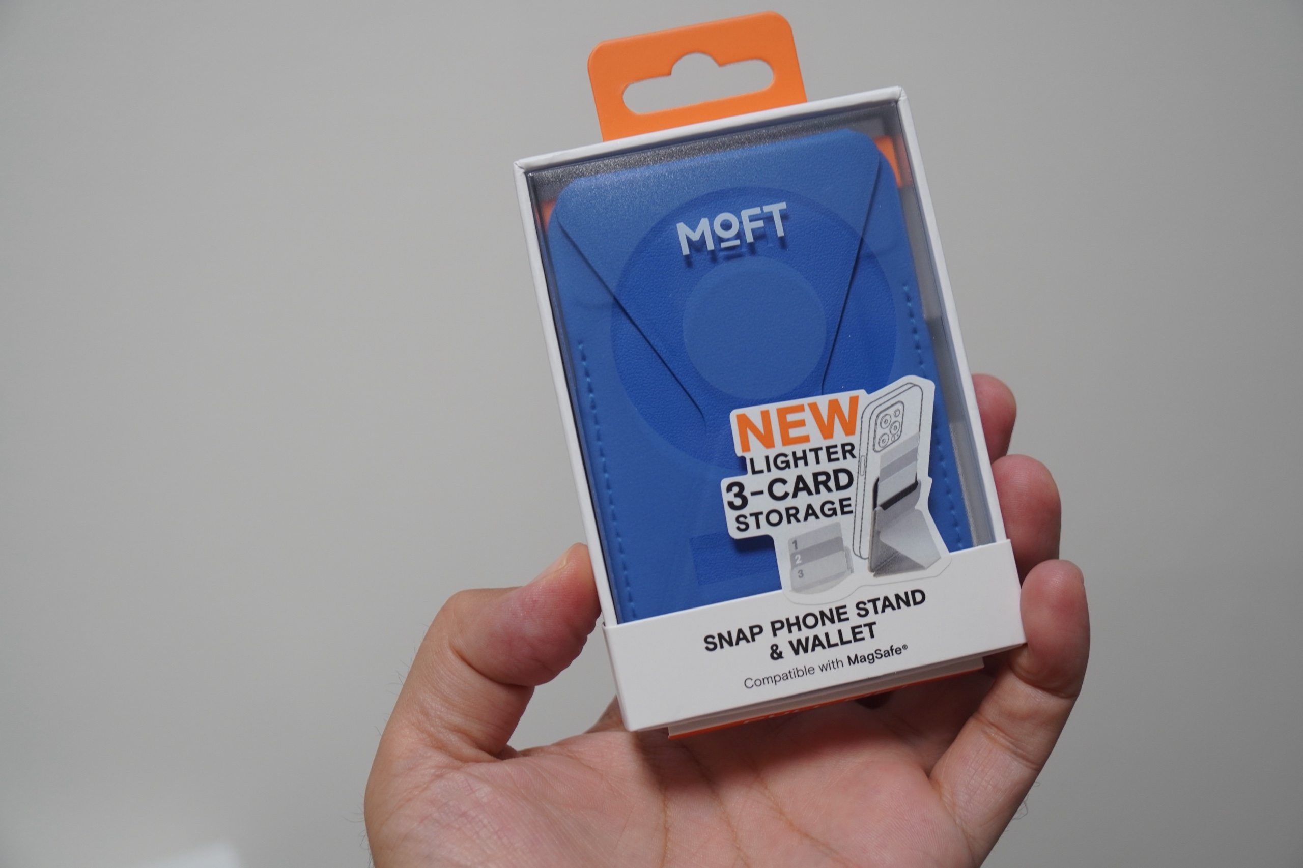 MOFT SNAP PHONE STAND & WALLETのパッケージを手に持ったところ。LIGHTER、3-CARD STORAGEの表記がある