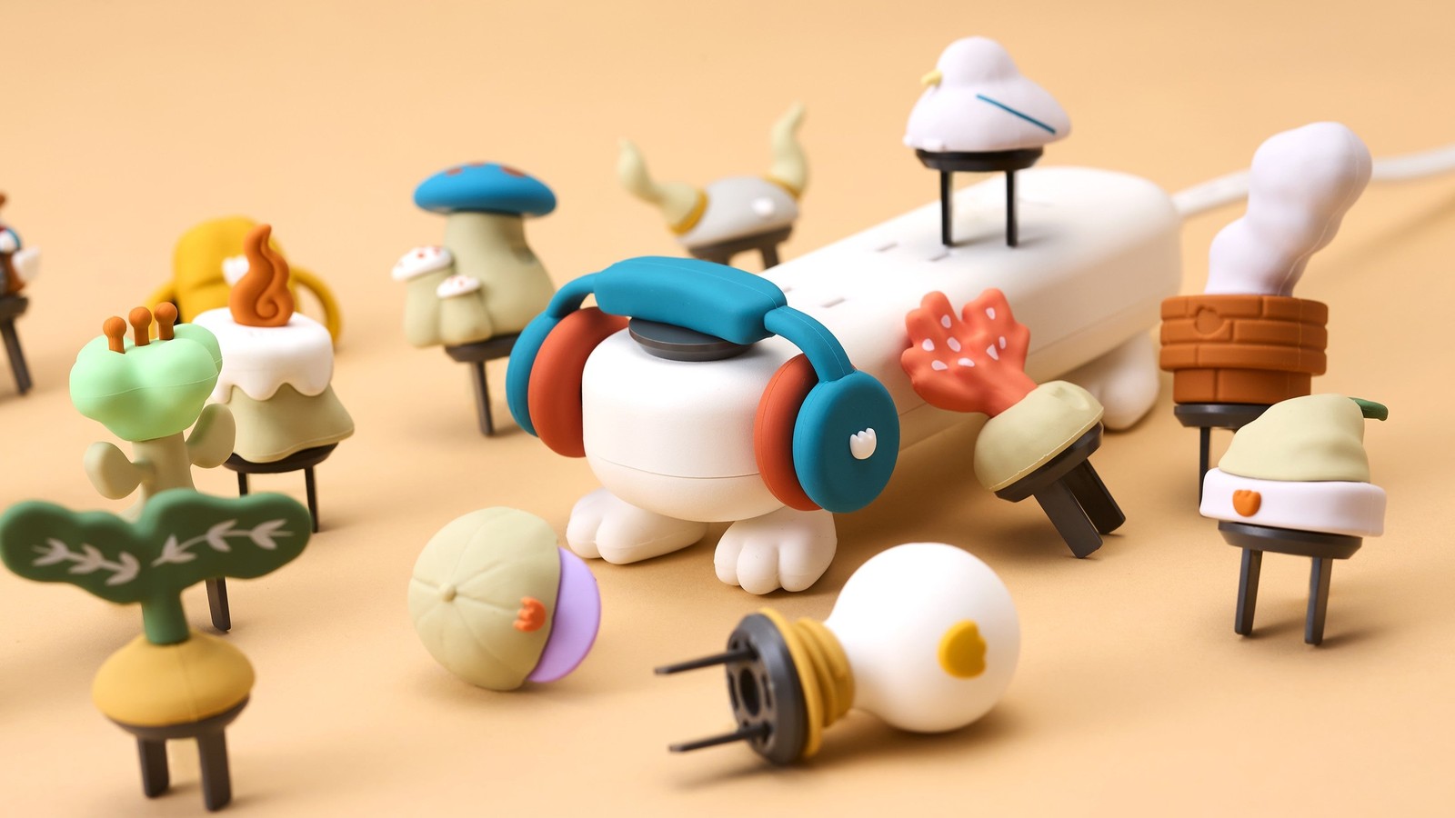 モンタップ用のフィギュア付きコンセントキャップが多数並ぶ。きのこ、木、植木鉢、帽子、電球など。下部にプラグの刃がある