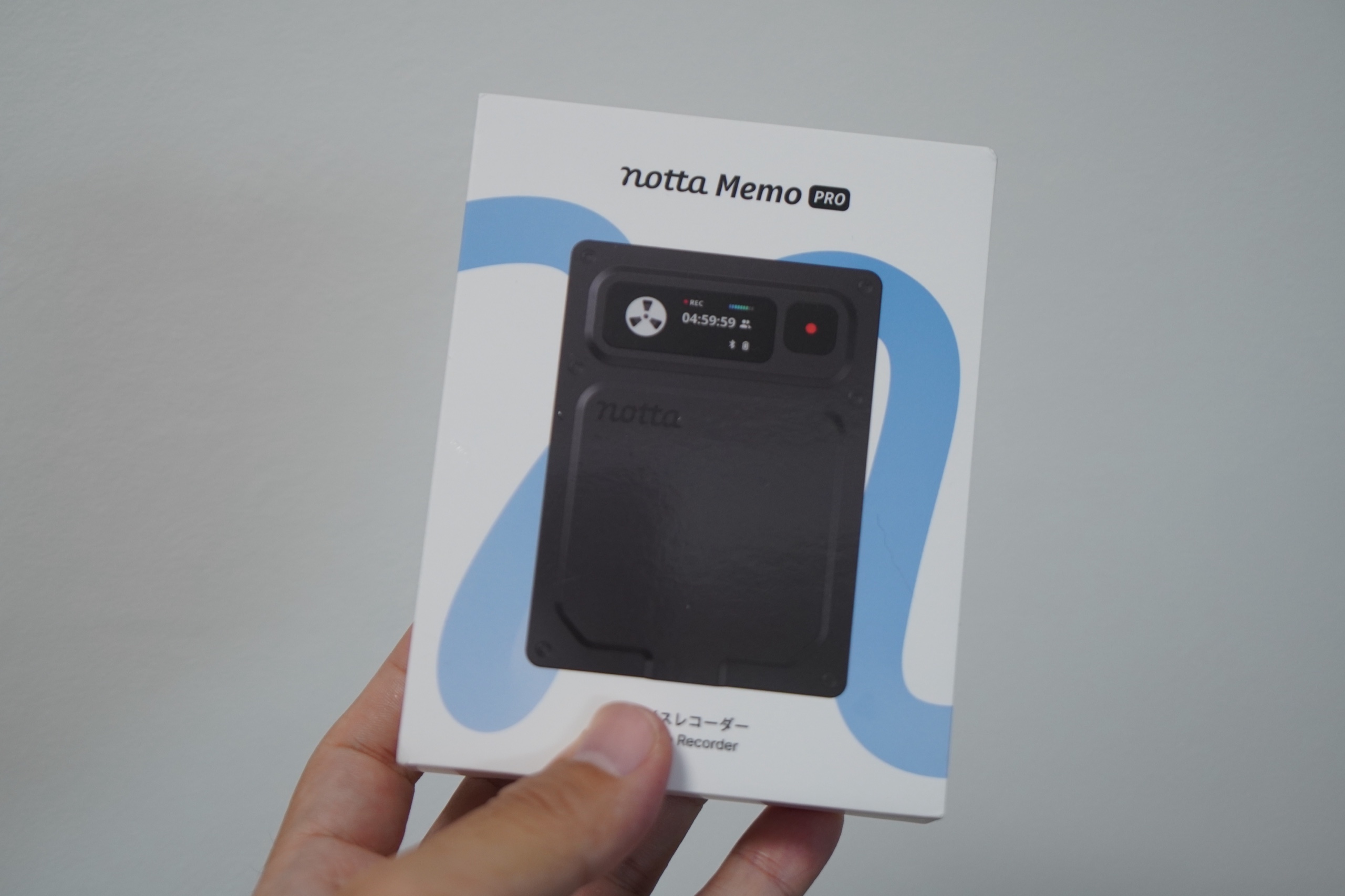 Notta Memo Proのパッケージを手に持ったところ。正面の窓から本体が見える