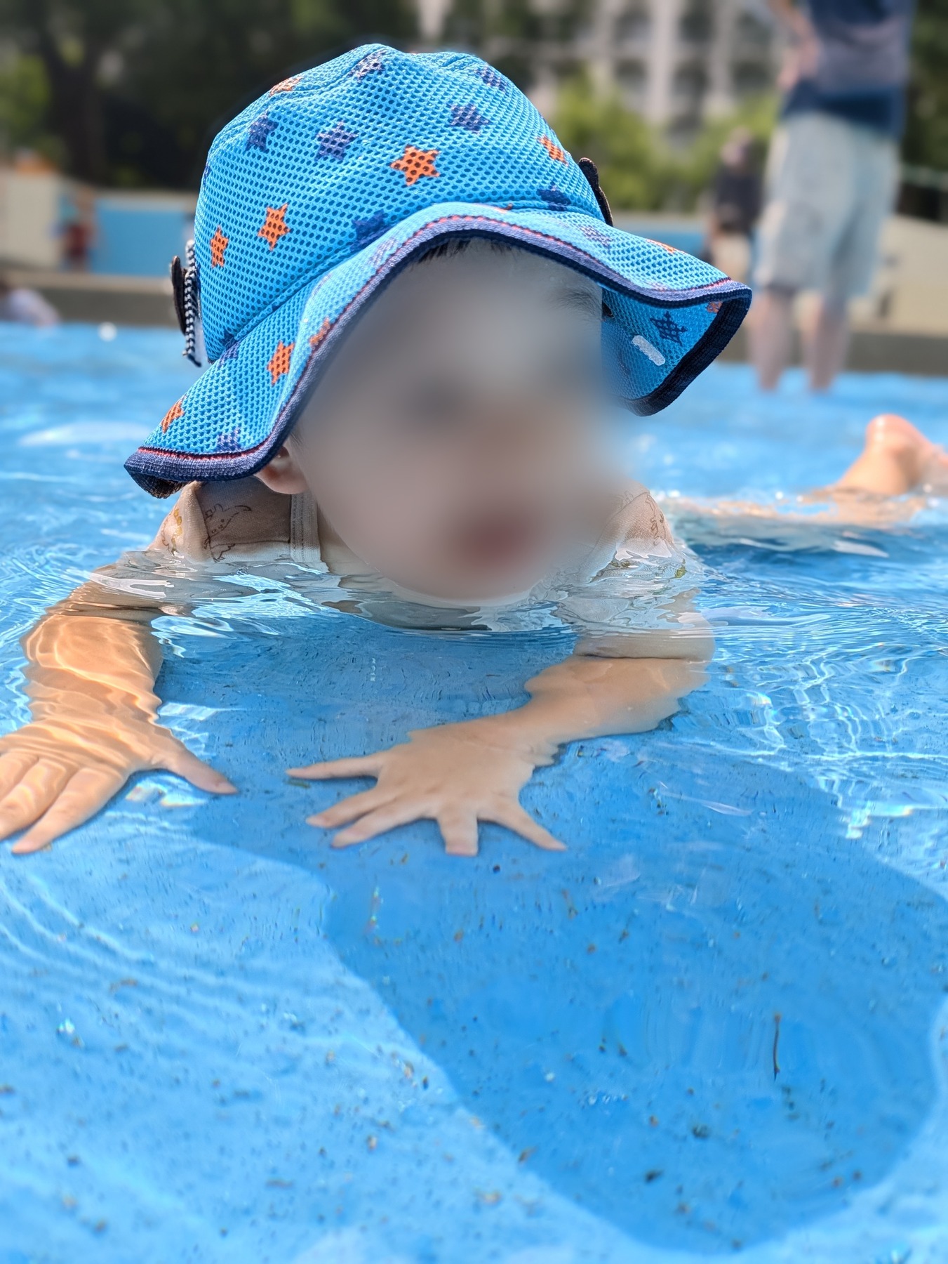 ポートレートモードで撮影した子ども。背景の人物が大きくぼけ、帽子のメッシュの目は解像している（顔はぼかし処理）
