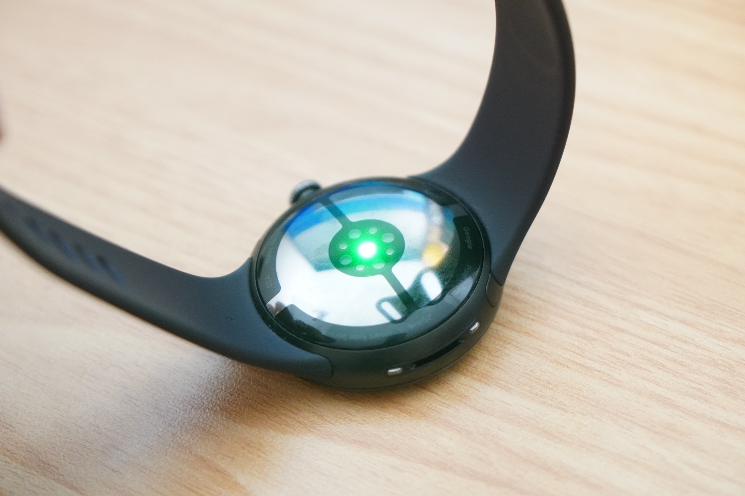Pixel Watch 5の裏面。円形のセンサー部の中央が緑色に発光し、その周囲に測定用の電極が並んでいる