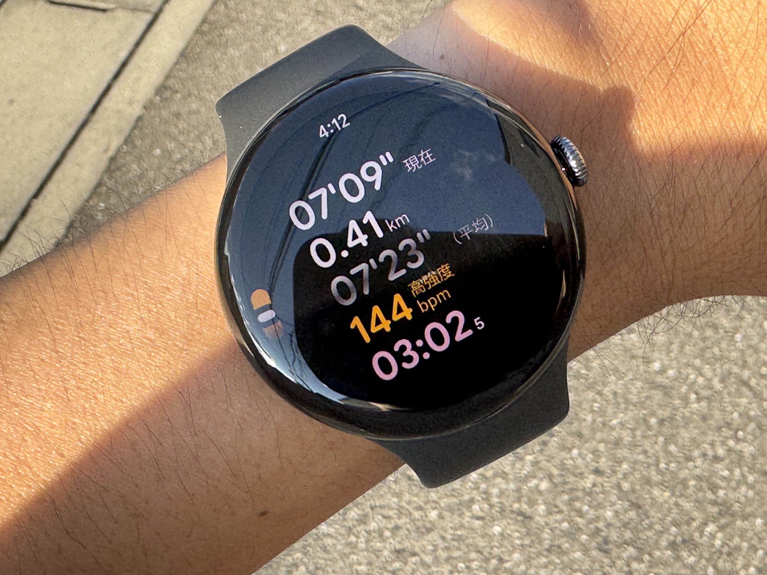 直射日光の下のPixel Watch 5のランニング画面。ペース7分09秒、距離0.41km、心拍144bpmが高強度のオレンジ色で表示されている