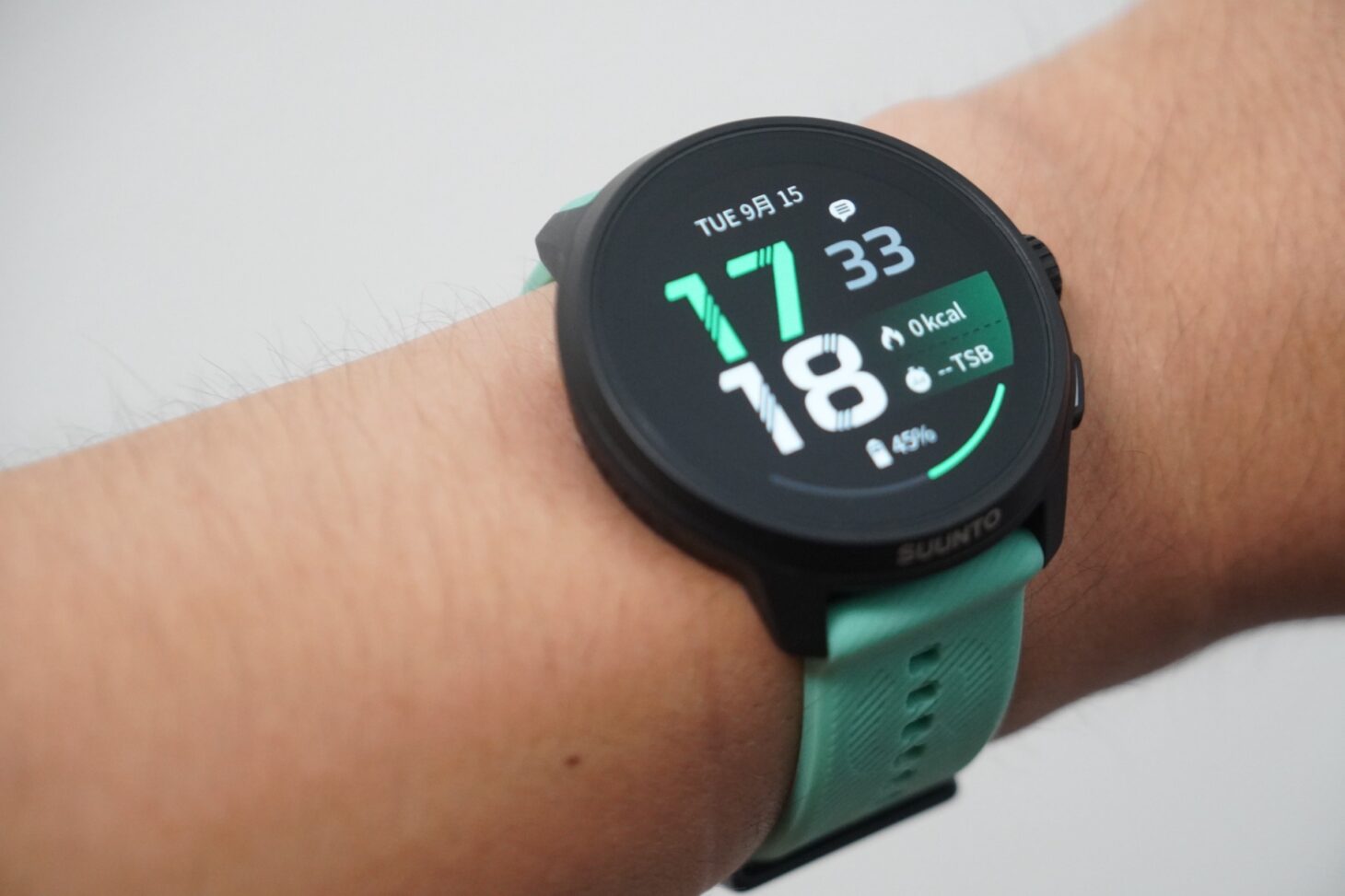 Suunto Run 2を手首に装着したところ。ミントグリーンのストラップで、画面には時刻とバッテリー45%が表示されている
