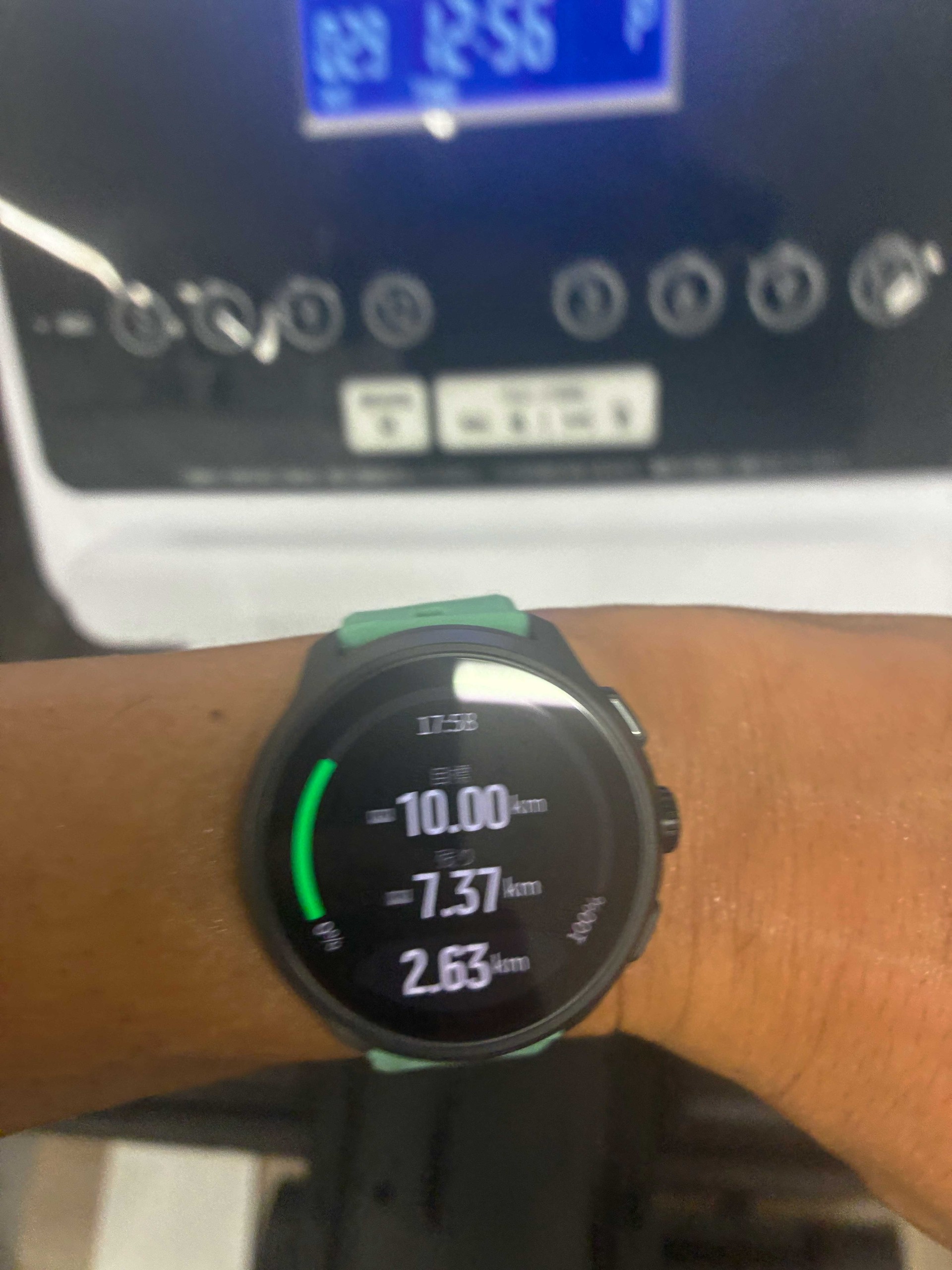 トレッドミルの前でSuunto Run 2を着けた腕を写した写真。ウォッチには目標10.00km、残り7.37km、2.63kmと表示されている