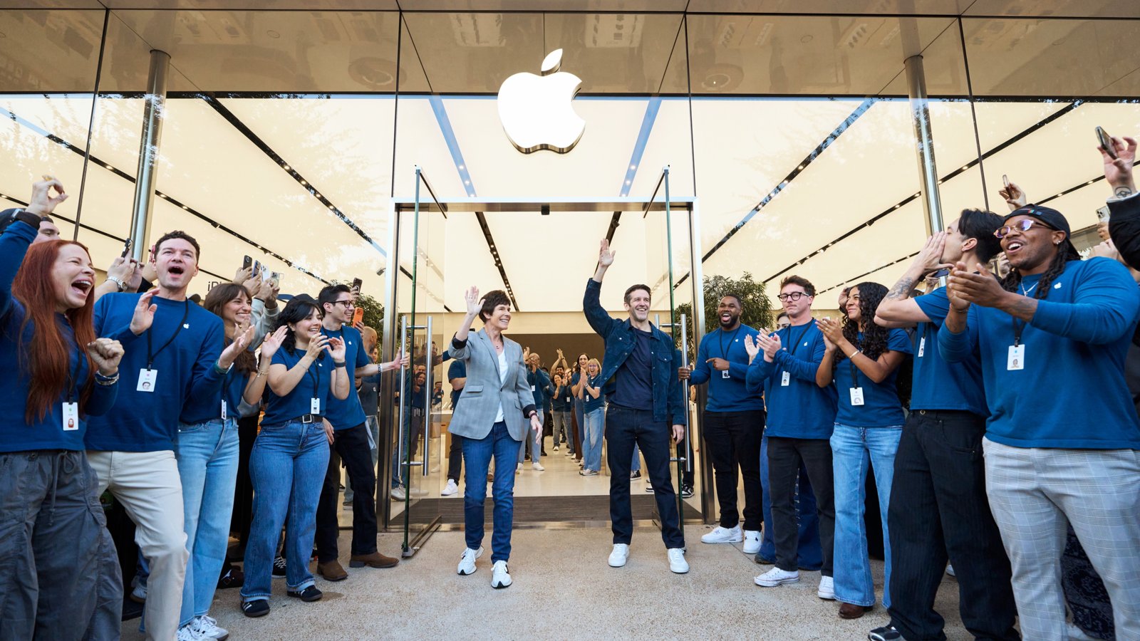 Apple Domain NORTHSIDEの入口でお客様を迎えるディアドラ・オブライエンとジョン・ターナス、両側に並ぶスタッフ