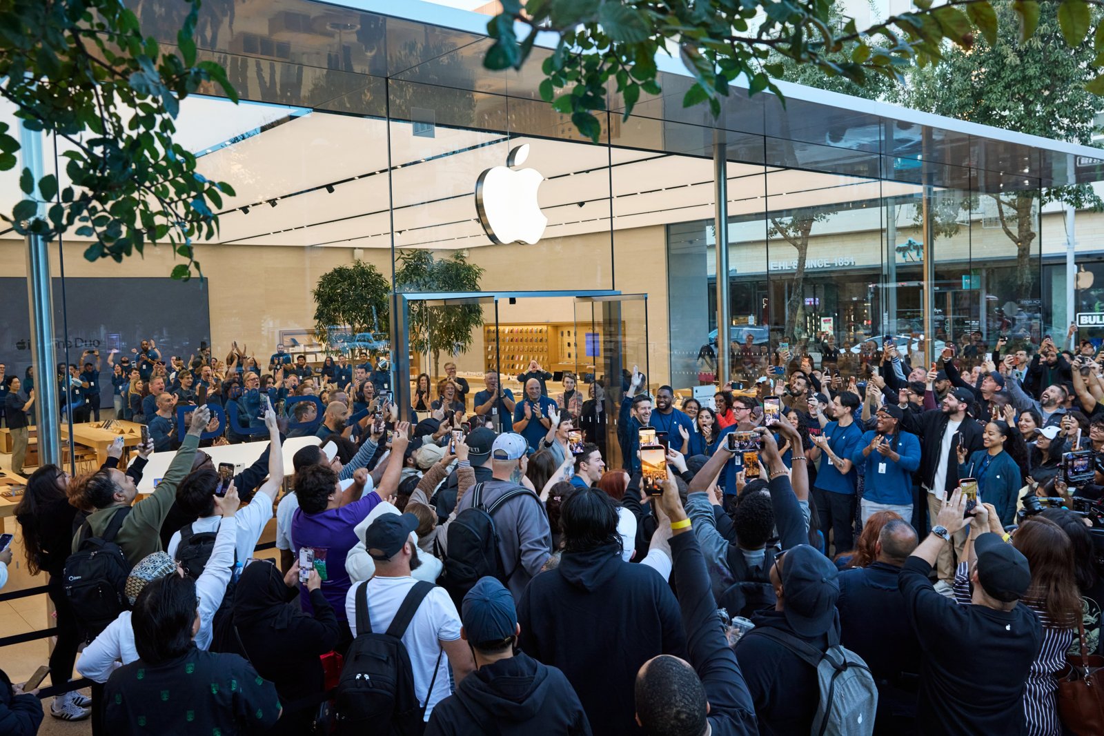 Apple Domain NORTHSIDEの店先に集まり手を挙げるお客様とスタッフ