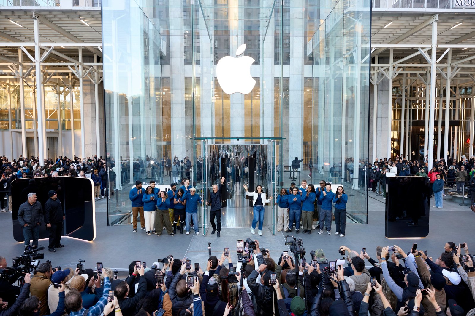 ガラスキューブの前に大きなiPhone Duoの模型が置かれたApple Fifth Avenueと集まった報道陣