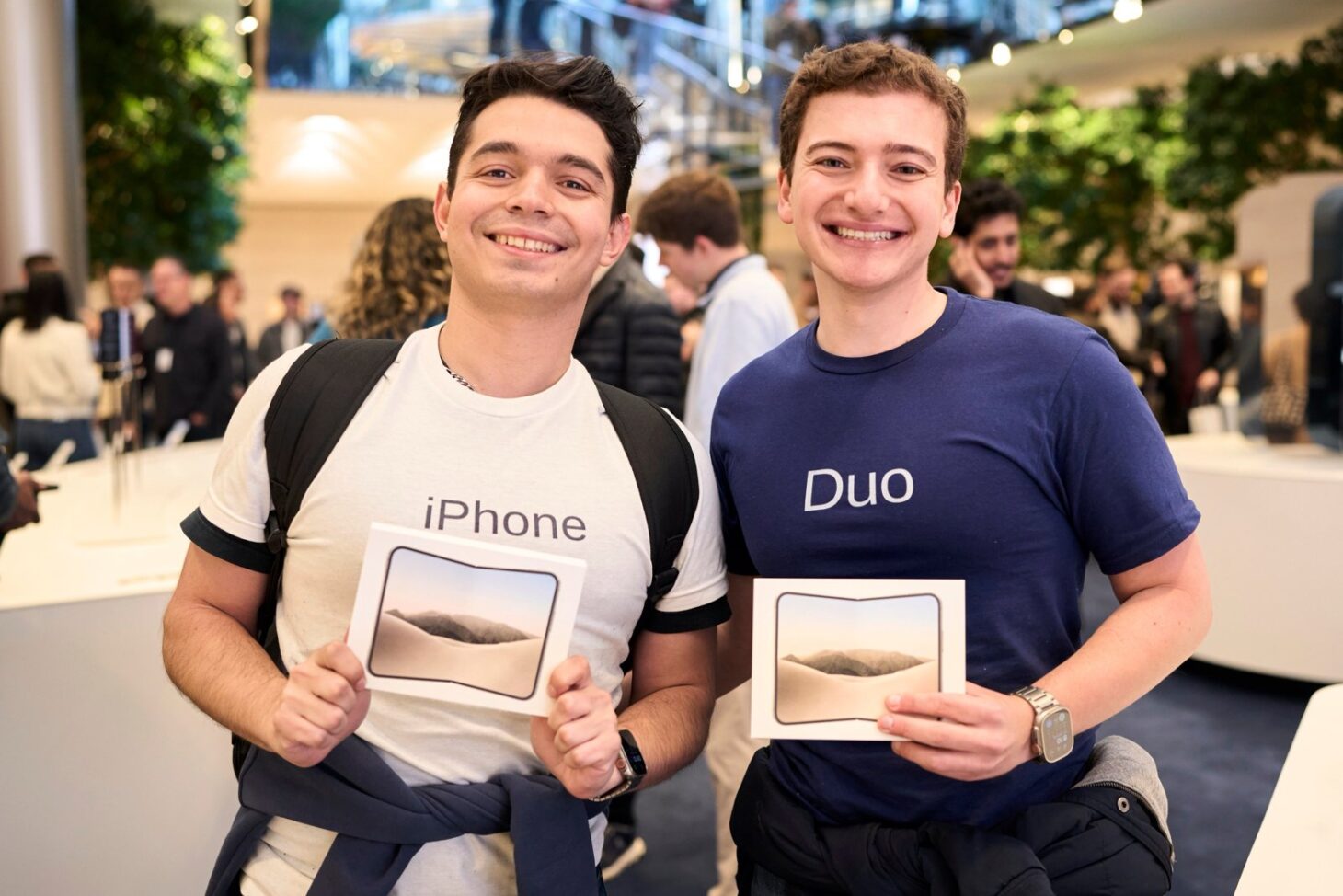 Apple Fifth AvenueでiPhone Duoの箱を持って笑顔を見せる2人のお客様