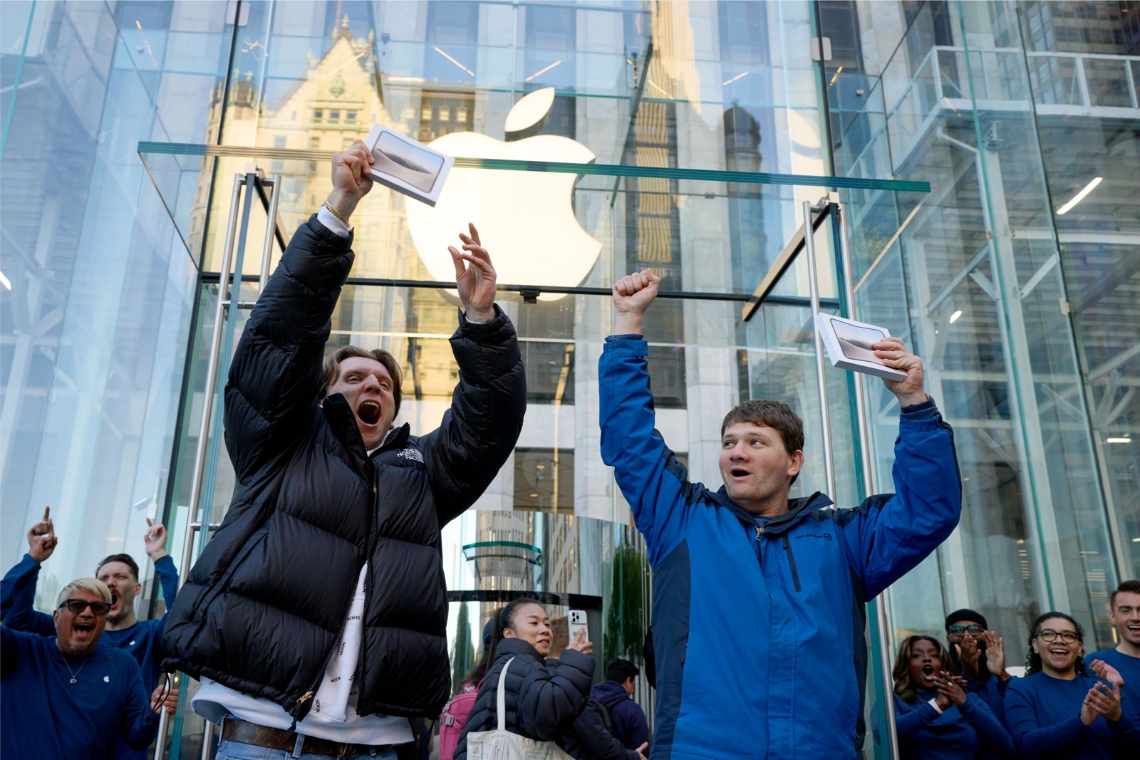 Apple Fifth Avenueのガラスキューブの前でiPhone Duoの箱を掲げて喜ぶお客様