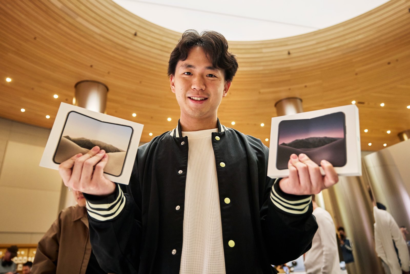 Apple Jing'anでiPhone Duoの箱を両手に持つお客様