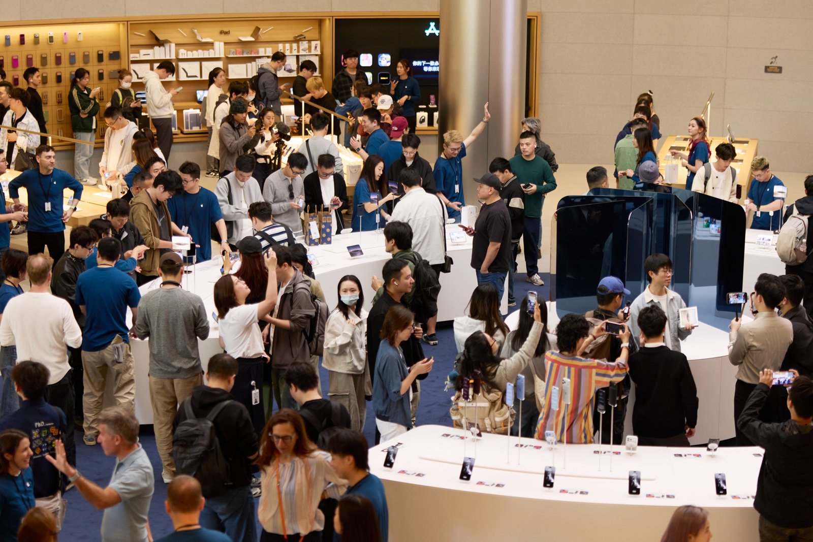 Apple Jing'anの店内でiPhone Duoの展示台を囲むお客様