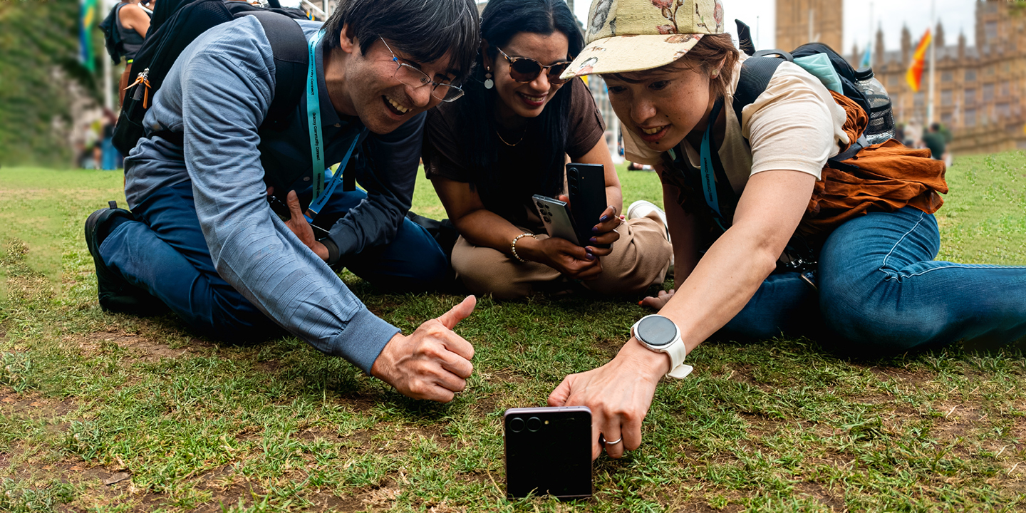 Galaxy Unpacked 2026で、他国のSamsung Membersと芝生に座ってGalaxyスマートフォンで撮影を楽しむ様子