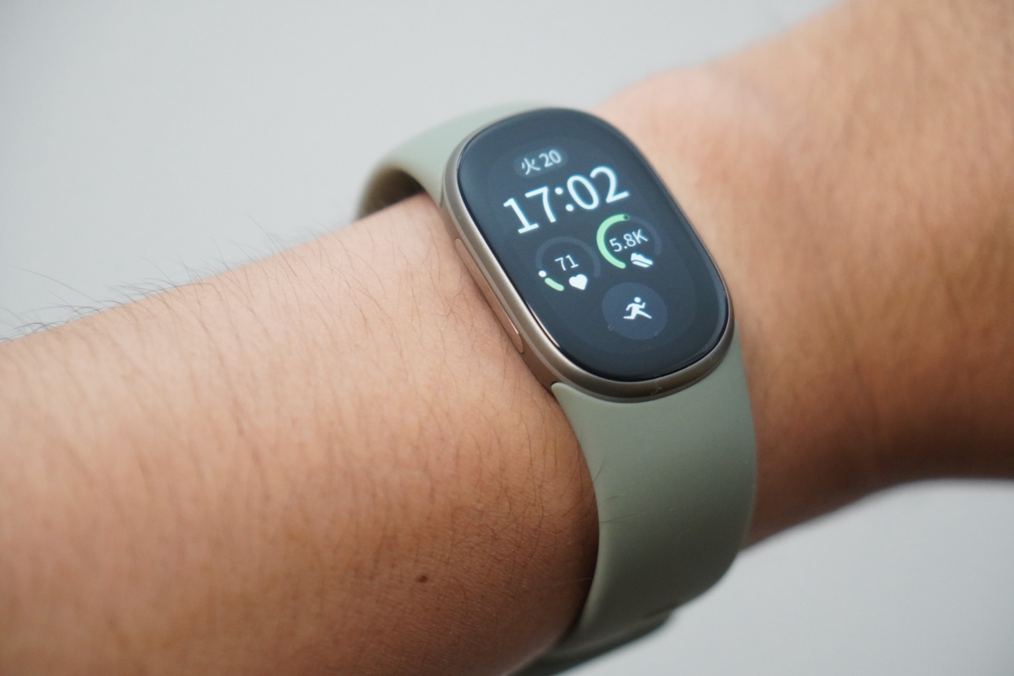Google Fitbit Edgeを手首に着けたところ。画面に時刻と歩数が表示されている