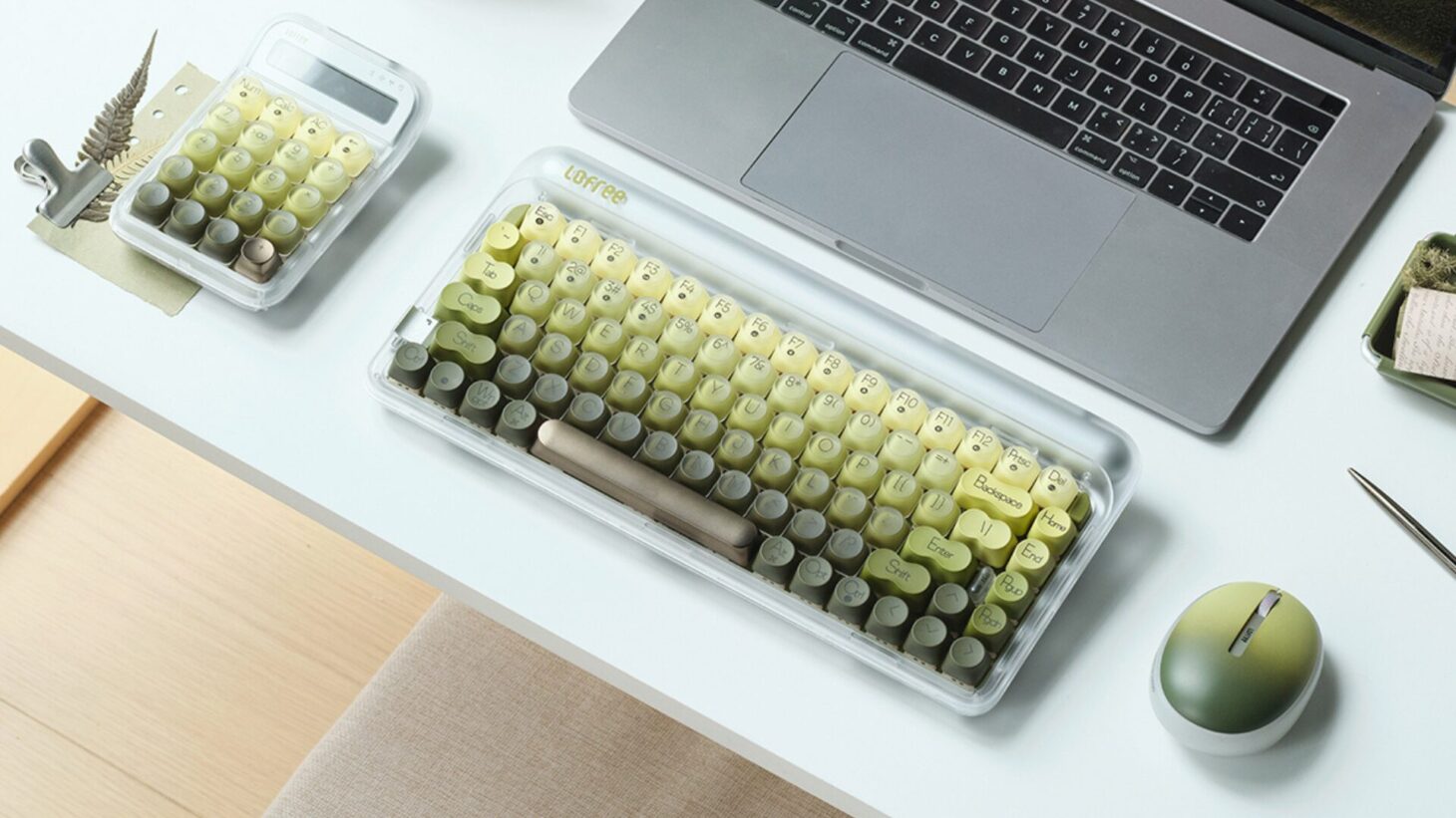 ノートPCの手前に並ぶLofree 432Hz Polar Mossのキーボード、テンキーパッド、マウス。グリーンのグラデーションと半透明のホワイトで色をそろえたシリーズ