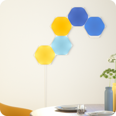 ダイニングの壁に六角形のNanoleaf Shapesを黄色と青で光らせた様子