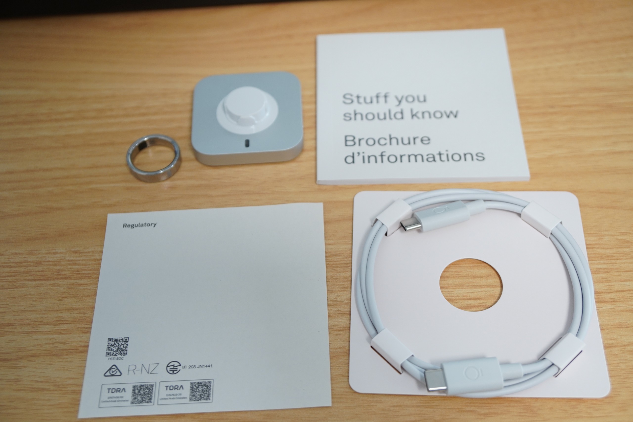 Oura Ring 5の同梱物。リング本体、四角い充電台、両端USB-Cのケーブル、説明書類
