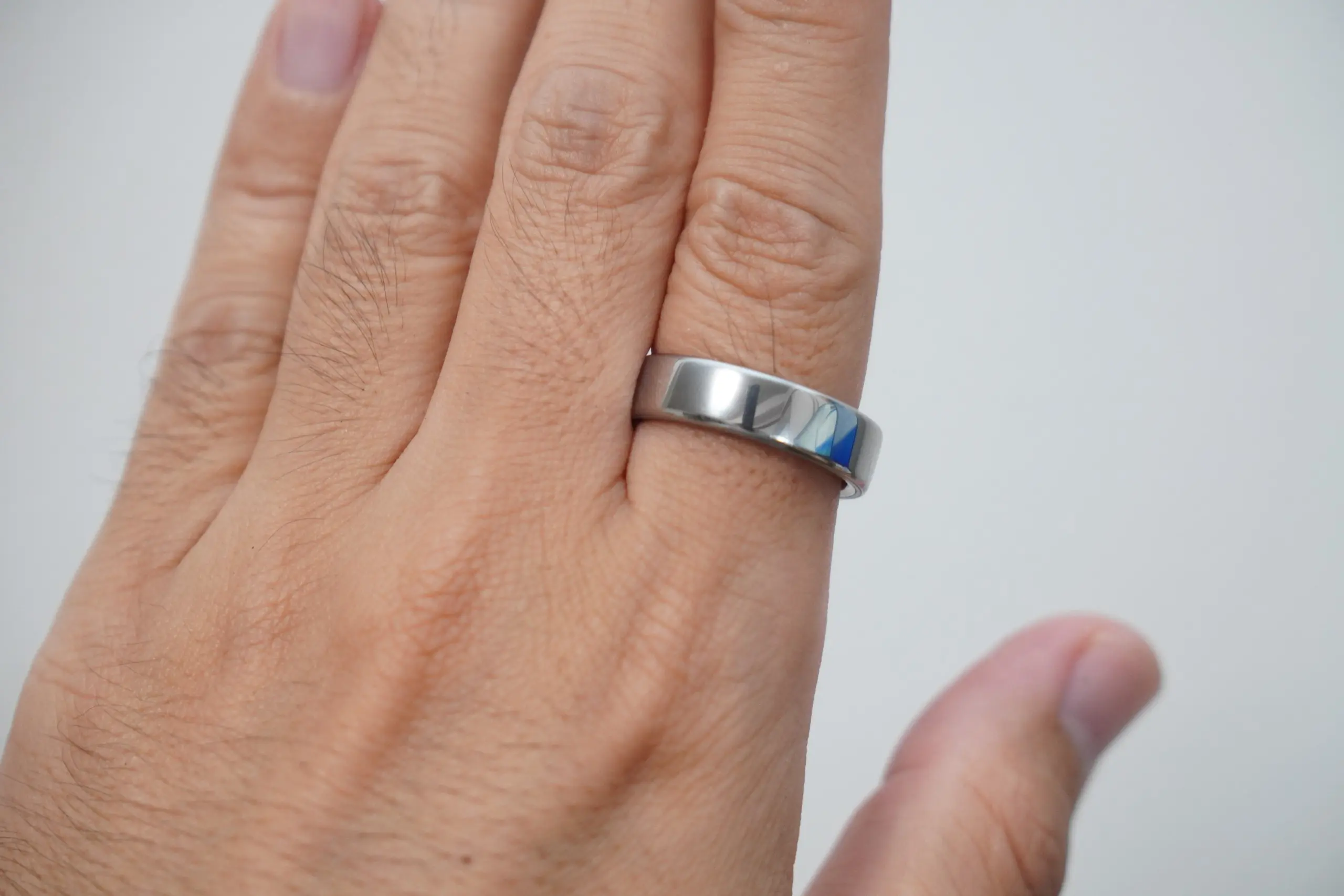 編集部で撮影したOura Ring 5。シルバーのリングを中指に着けた手の甲