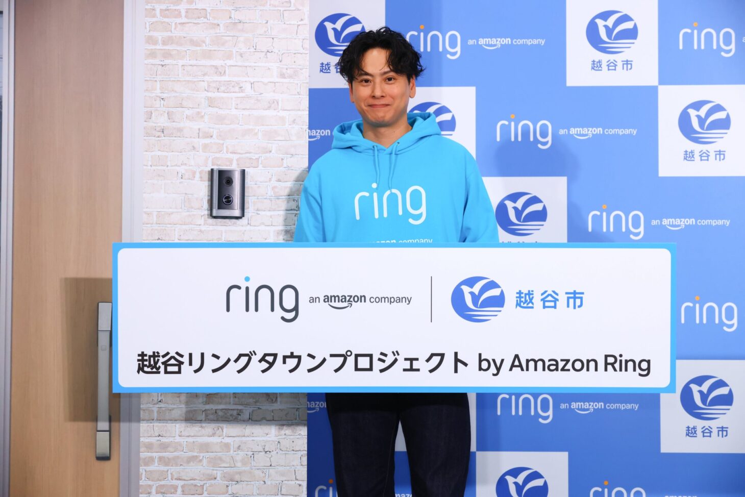 越谷リングタウンプロジェクト by Amazon Ringのパネルを持つ山下健二郎さん