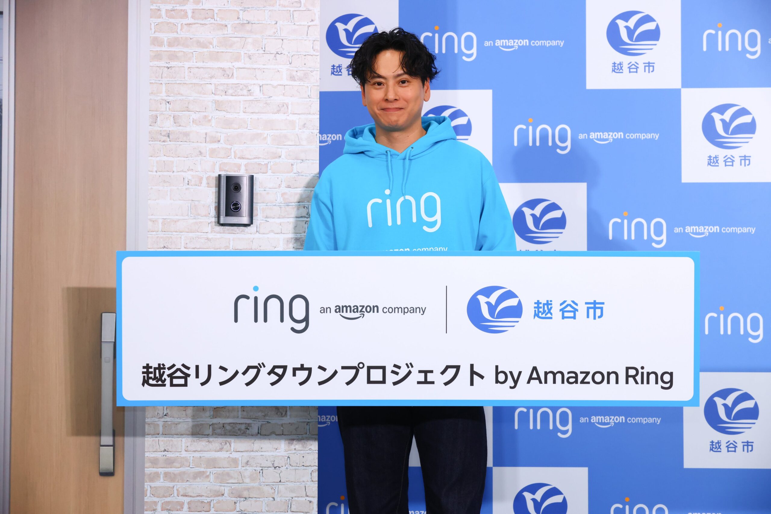 越谷リングタウンプロジェクト by Amazon Ringのパネルを持つ山下健二郎さん