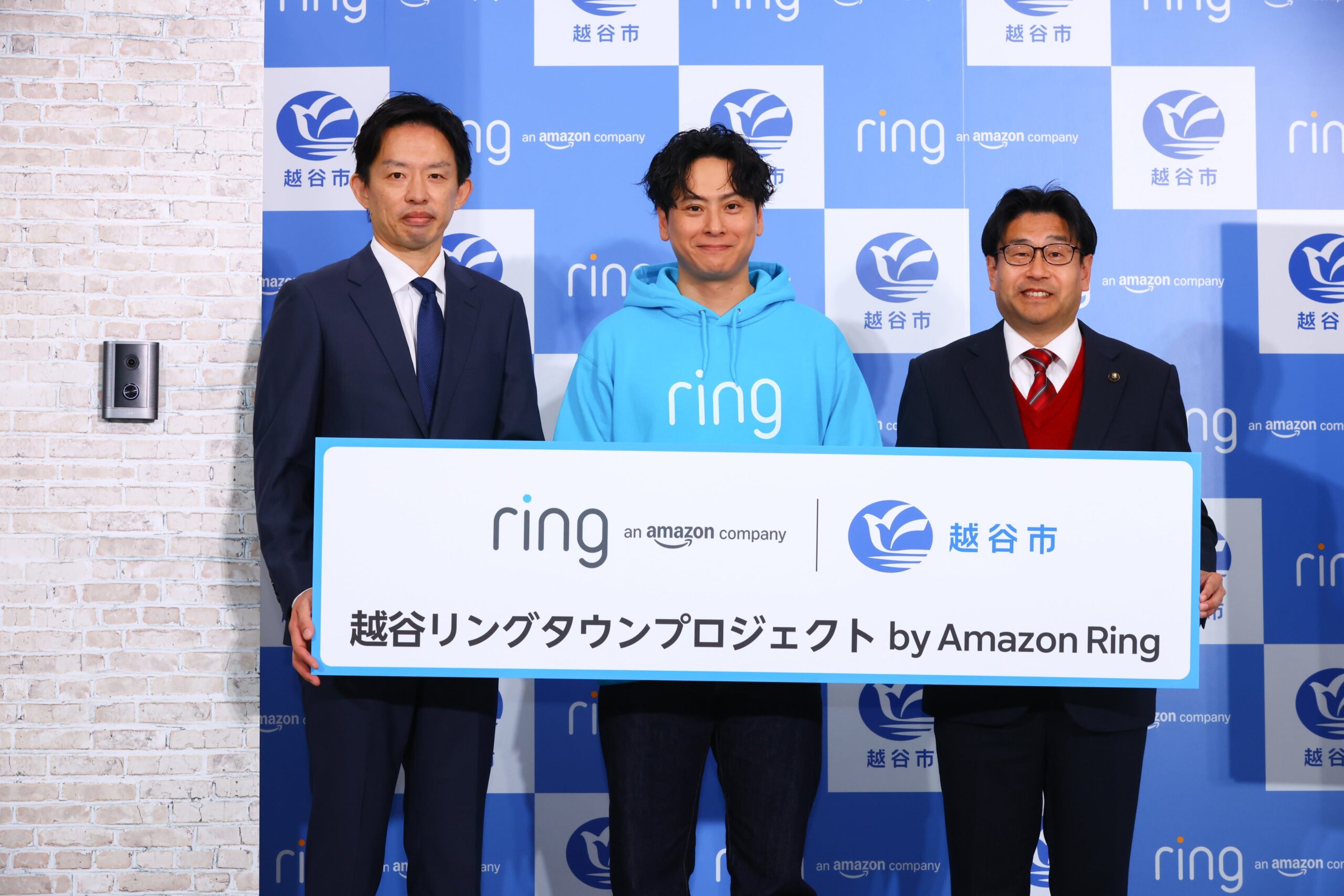 瀬口雄介さん、山下健二郎さん、福田晃越谷市長の3人が越谷リングタウンプロジェクトのパネルを持って並ぶ発表会の様子
