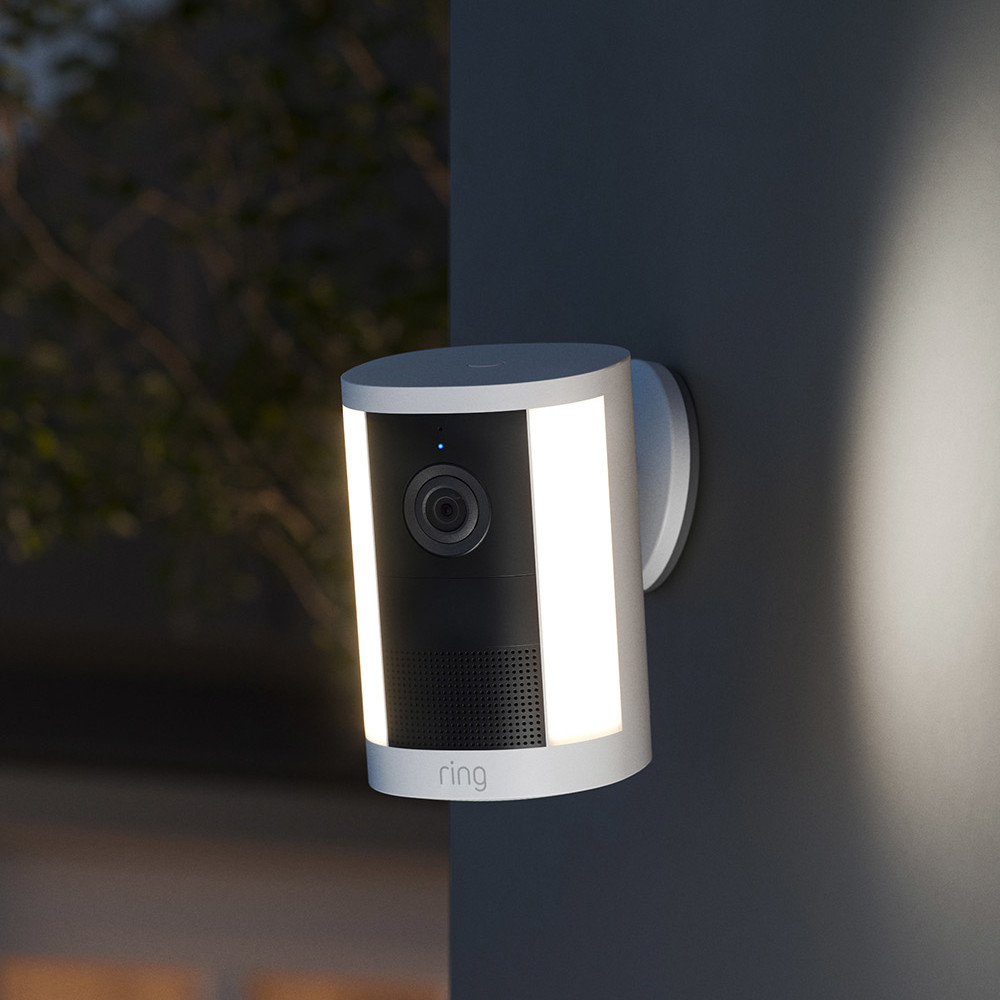 夕暮れの外壁でセンサーライトを点灯させたRing Spotlight Cam 2K。550ルーメンのライトで周囲を照らす様子。
