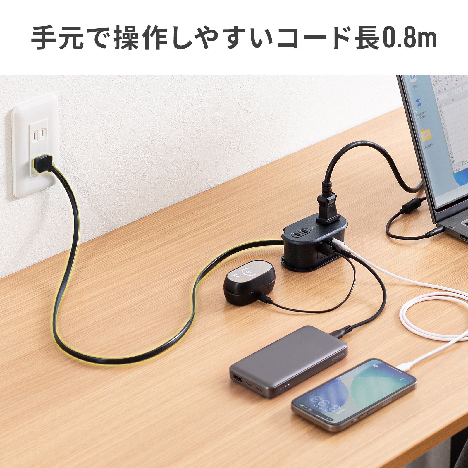 足元の壁コンセントから0.8mのコードで机の上にTAP-MC2A1AC2BKを置き、ノートパソコンやスマートフォンを充電している様子