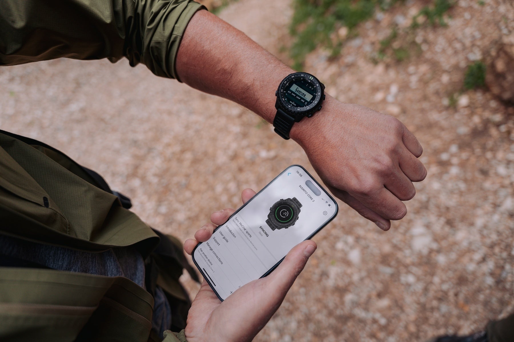 手首のSuunto Core 2と、Suuntoアプリを開いたスマートフォンを持つ手元