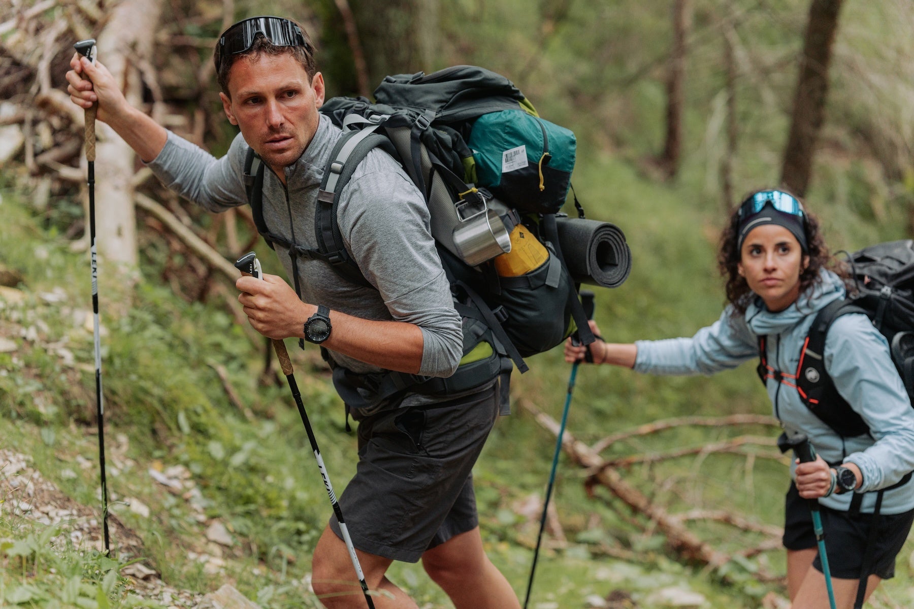 大きなバックパックを背負って森を歩く登山者の手首に着けたSuunto Core 2