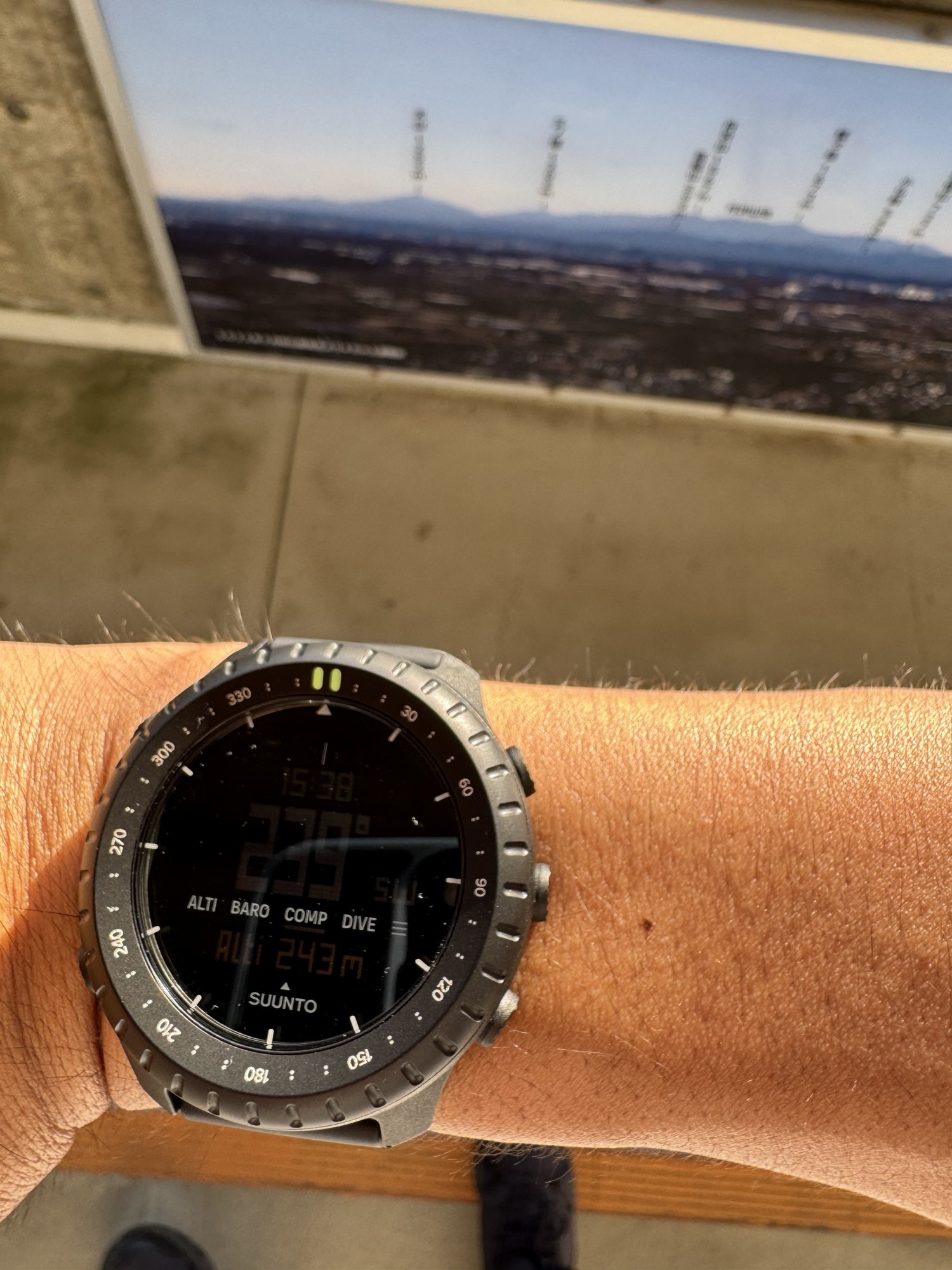 桜山展望台の上でSuunto Core 2のコンパスを富士山の方角に向けたところ。229度、下段に高度243m。奥に山並みの案内板がある