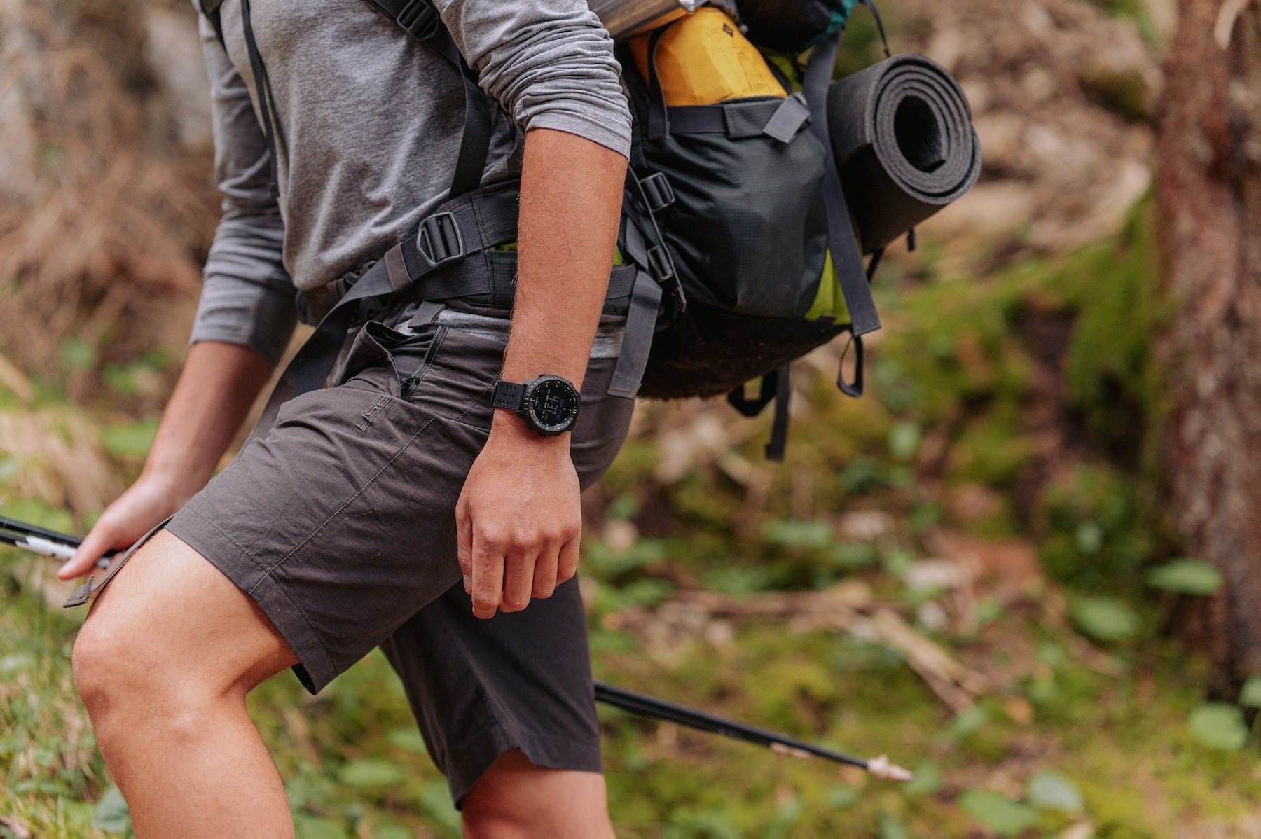トレッキングポールを持って山道を歩く2人の登山者。手首にSuunto Core 2を着けている