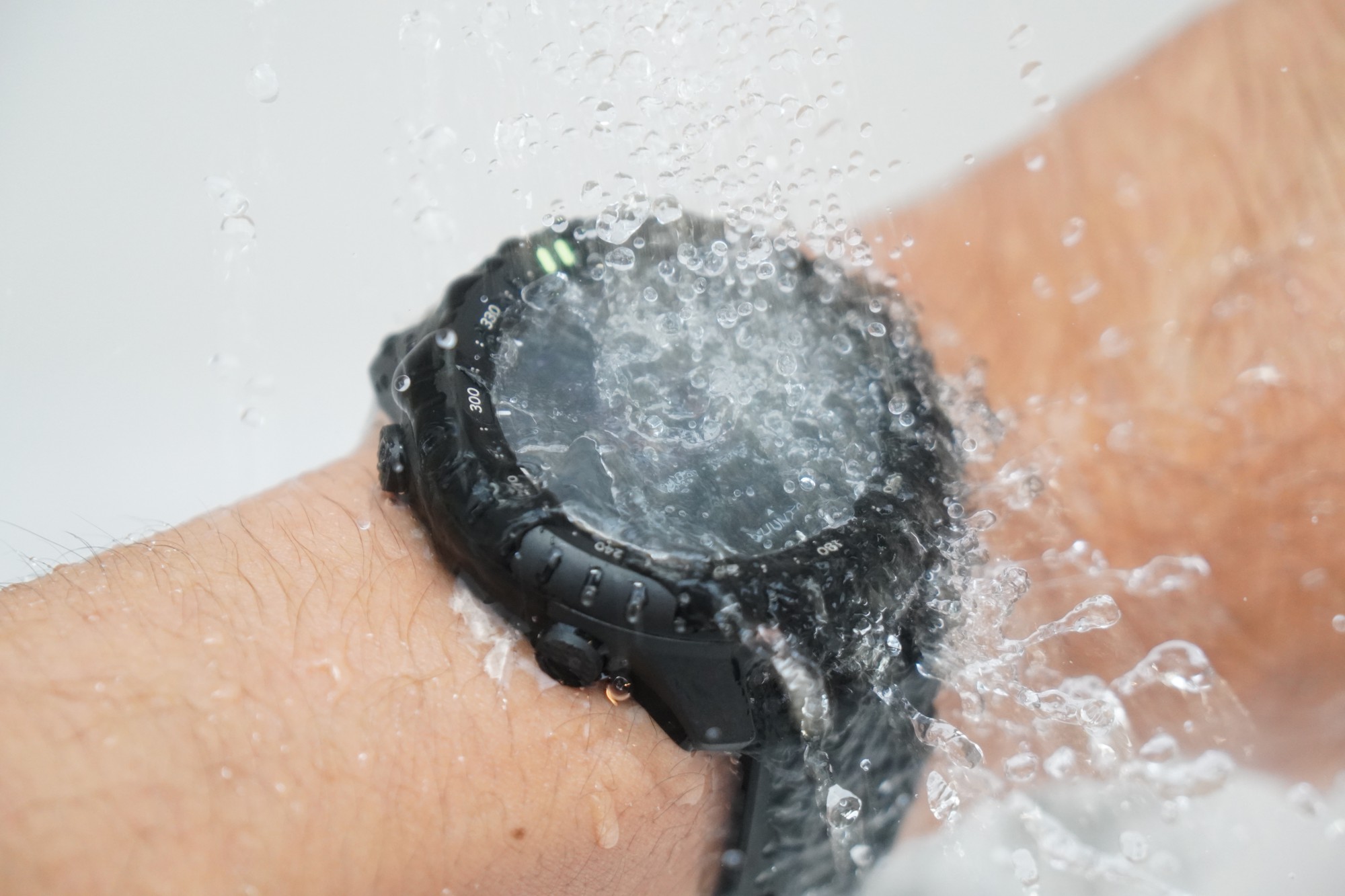 腕に着けたSuunto Core 2に水道の水をかけているところ。画面の上で水が跳ねている