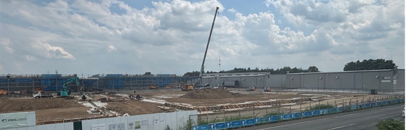 腕時計型センサーの着用試験を行った建設現場。クレーンや重機が並ぶ広い敷地