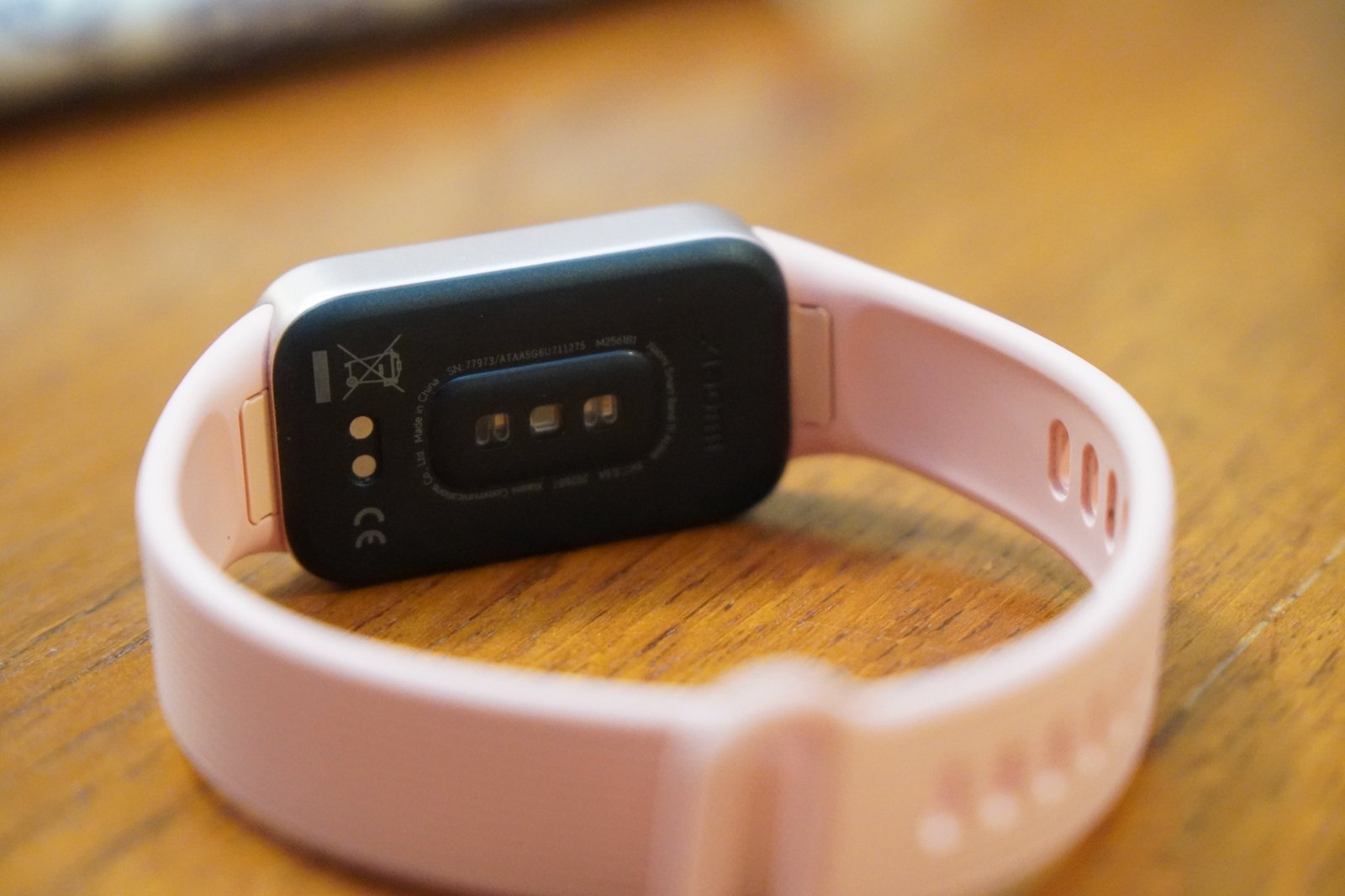 Xiaomi Smart Band 11 Activeの裏面。黒い裏ぶたの中央に心拍を測るセンサー、左側に磁気充電用の2つの接点がある