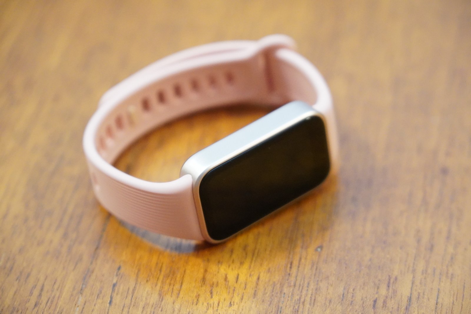 画面を消した状態のXiaomi Smart Band 11 Active。淡いゴールドのメタリック調フレームがピンクのストラップとつながっている
