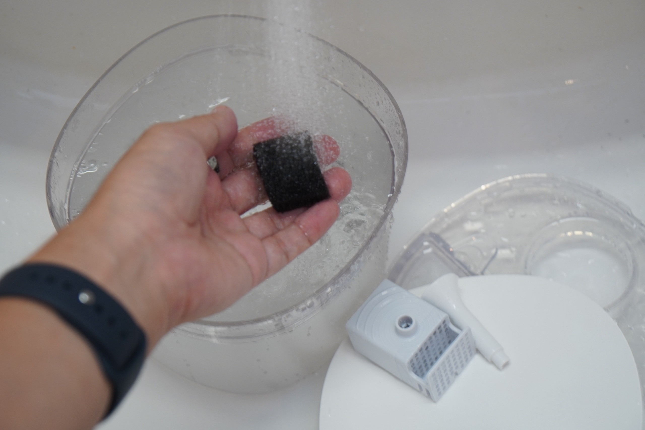 ポンプのスポンジを流水で洗っているところ