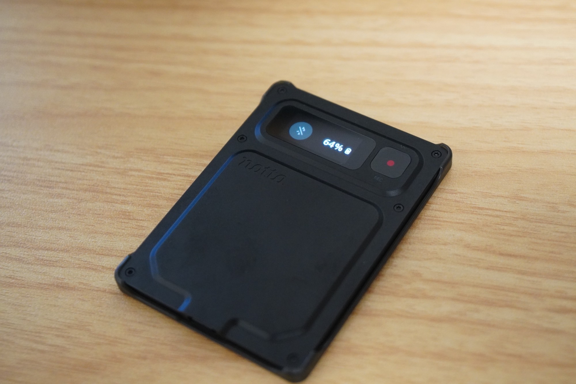 机に置いたNotta Memo Pro。画面にバッテリー残量64%が表示されている