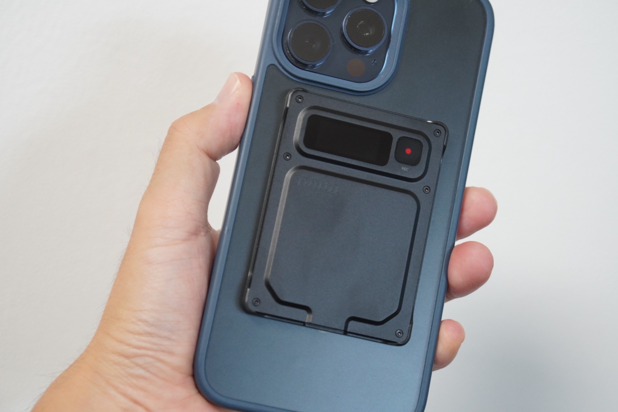 Notta Memo Proを背面に付けたiPhoneを手に持ったところ