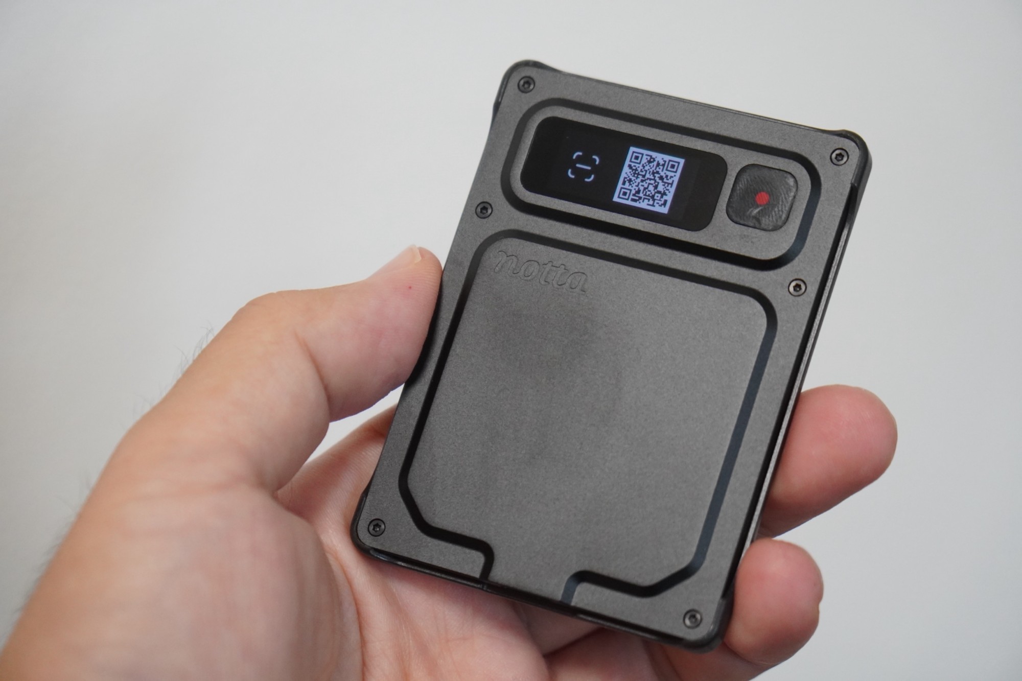 手に持ったNotta Memo Pro。画面にアプリと接続するためのQRコードが表示されている