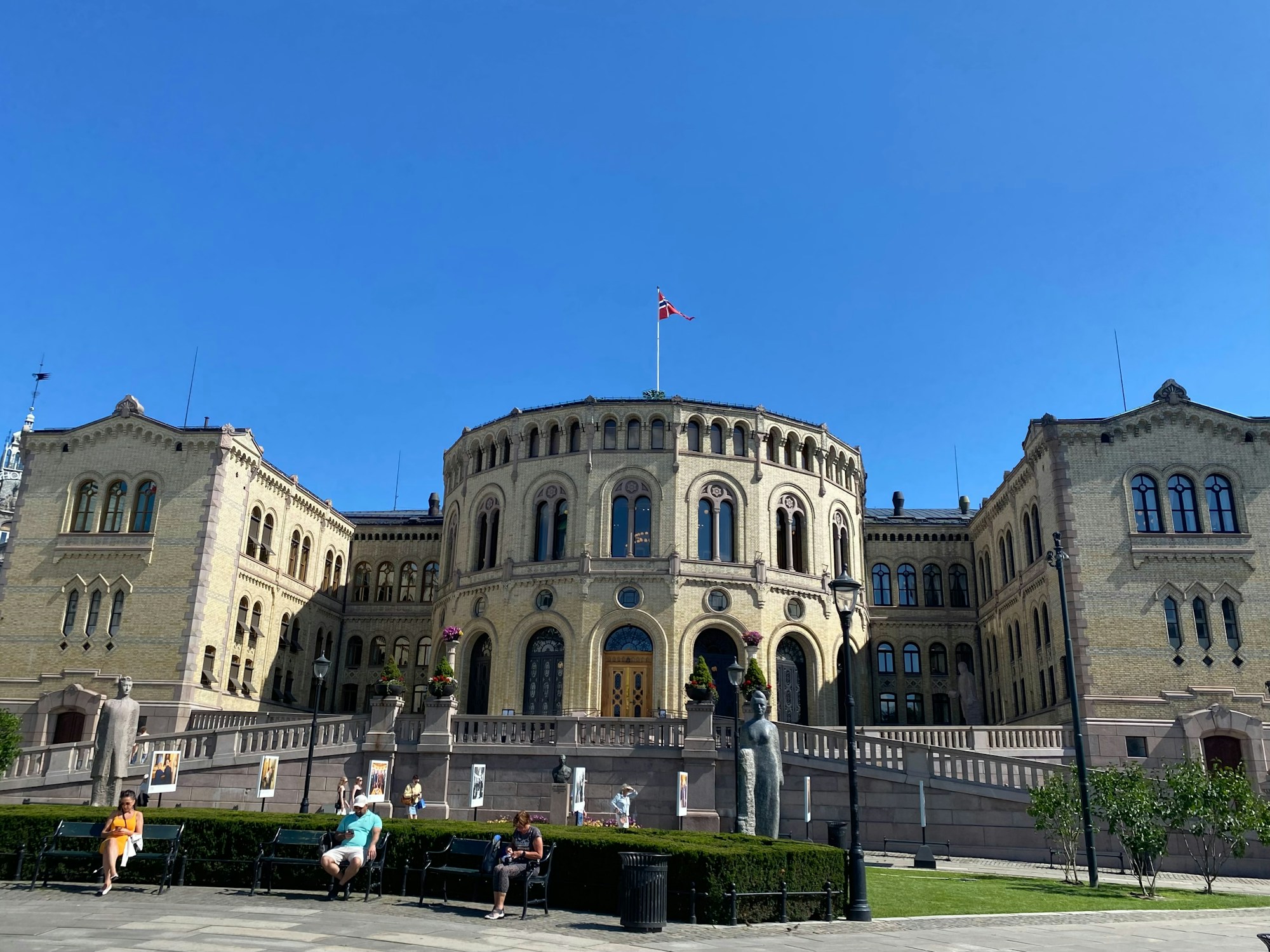 青空の下でノルウェーの国旗が掲げられたオスロの国会議事堂(ストーティング)
